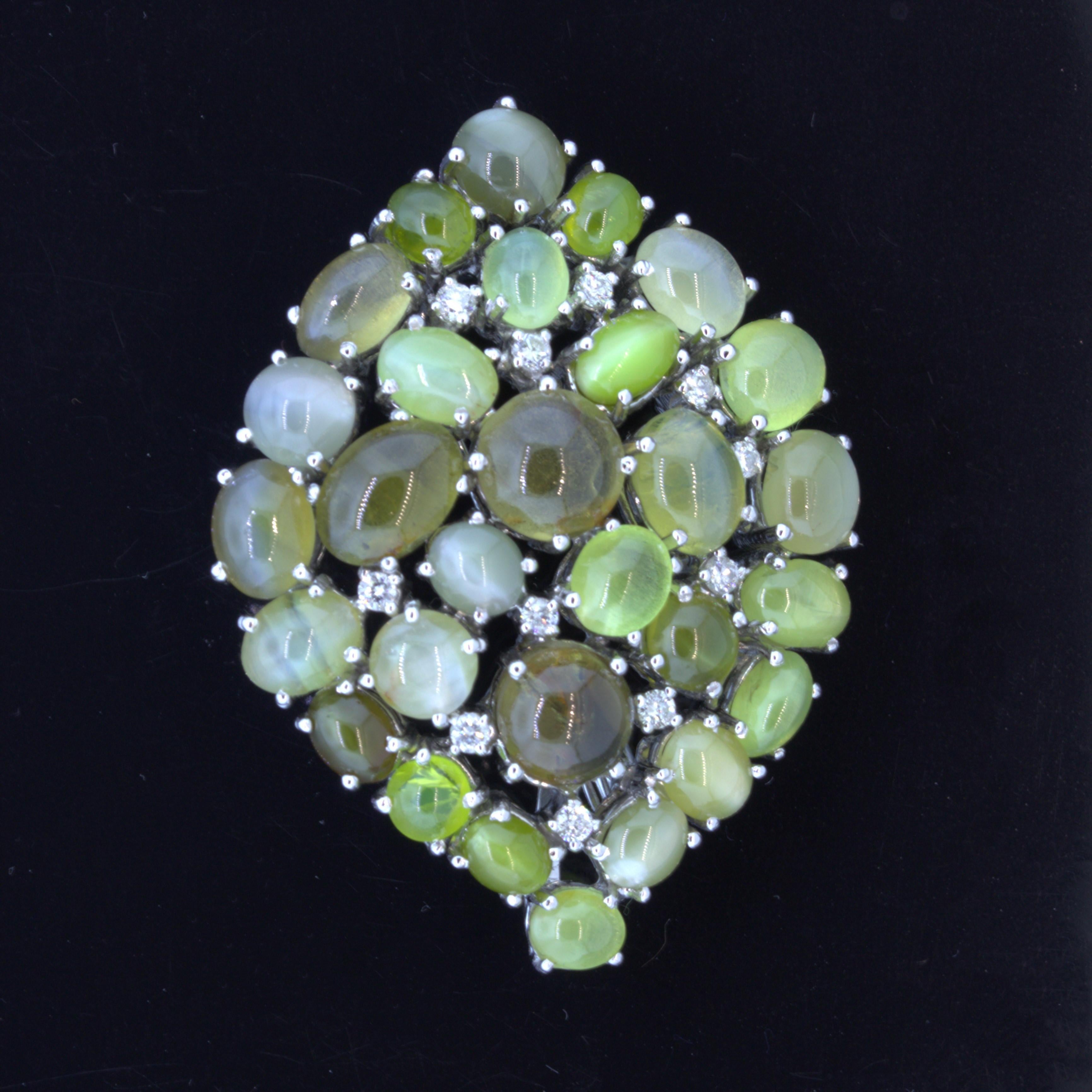 A fun and sleek brooch featuring 29 cats eye chrysoberyl weighing a total of 33.78 carats. Each stone has wonderful chatoyancy, cats eye effect, making it appear as if 29 eyes are looking at you from different directions! The brooch is complemented