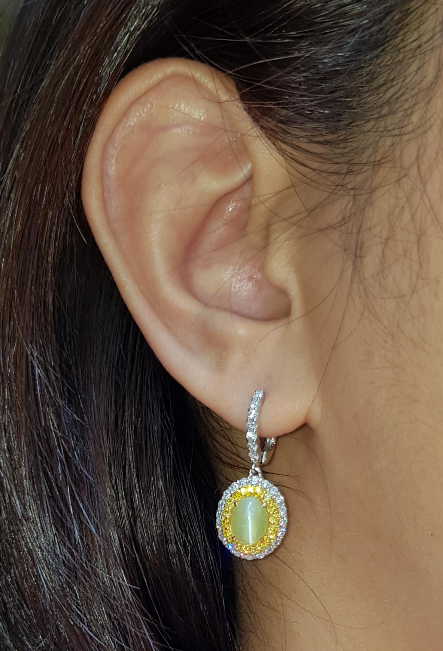 Cat's Eye 3.82 carats with Diamond 0.94 carat and Yellow Diamond 0.60 carat Earrings set in 18 Karat White Gold Settings

Width:  1.2 cm 
Length: 2.8 cm
Total Weight: 6.66 grams

