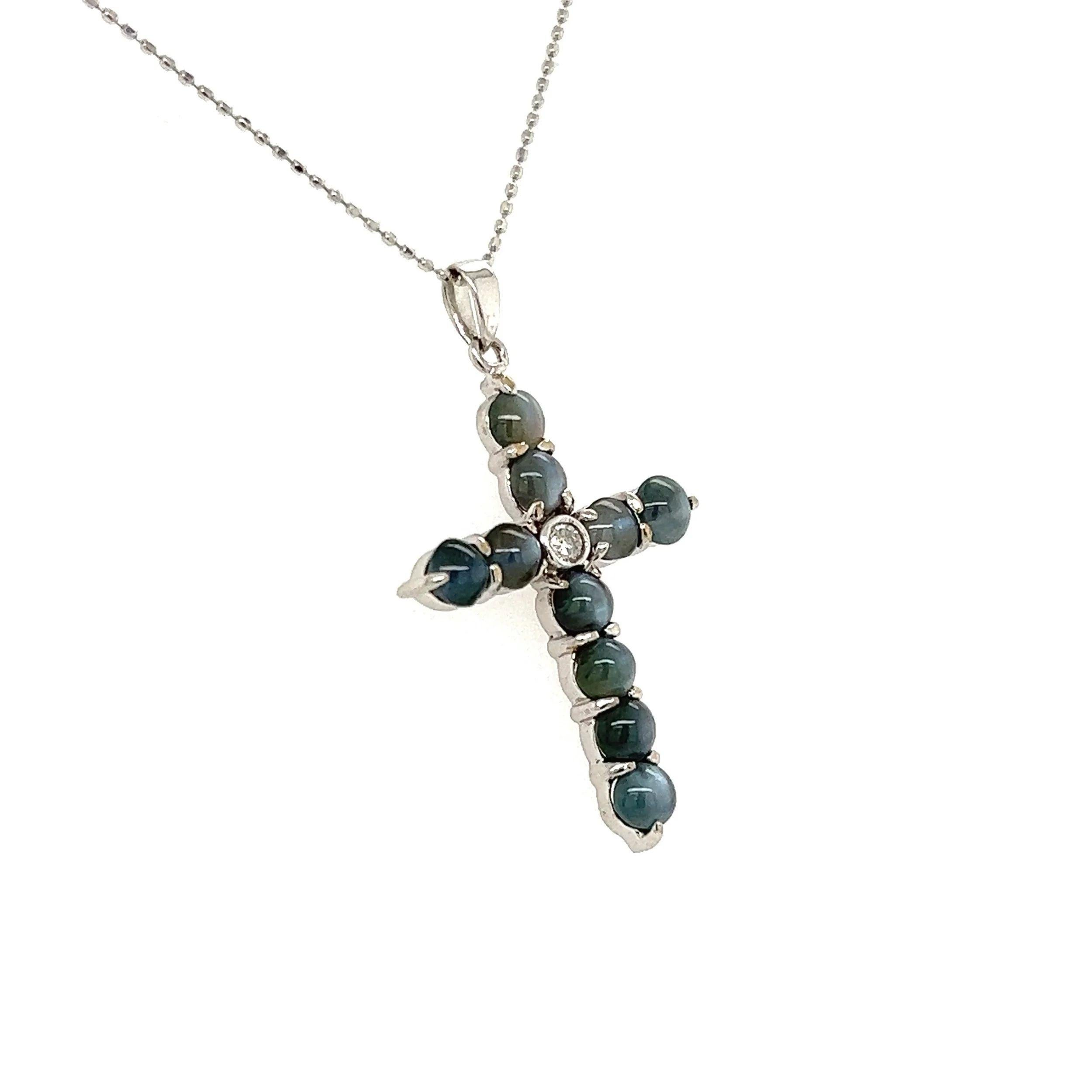 Simply Beautiful! Finely Detailed Cat’s Eye Chrysoberyl and Diamond Gold Cross. Hand set with Cat’s Eye Chrysoberyl weighing approx. 2.48tcw and centering a 0.05 Carat Diamond. Hand crafted in 18K White Gold. Suspended from a 16” Gold Link Chain.