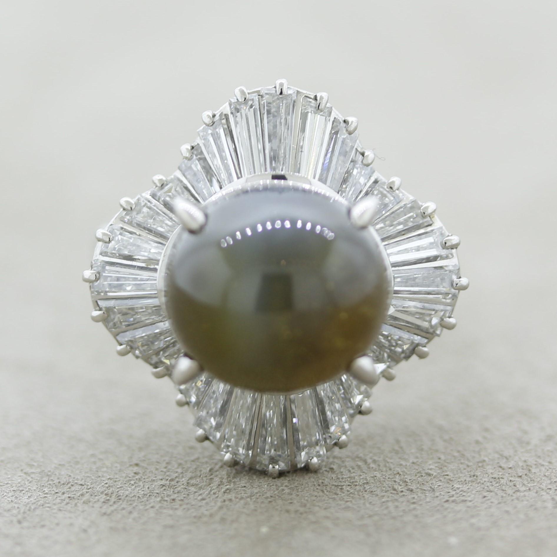 A large and impressive cats eye chrysoberyl takes center stage. It weighs 12.29 carats and has a strong cats eye (known as chatoyancy) when a light hits the stone or when it's outside in direct sunlight. It is complemented by 2.34 carats of
