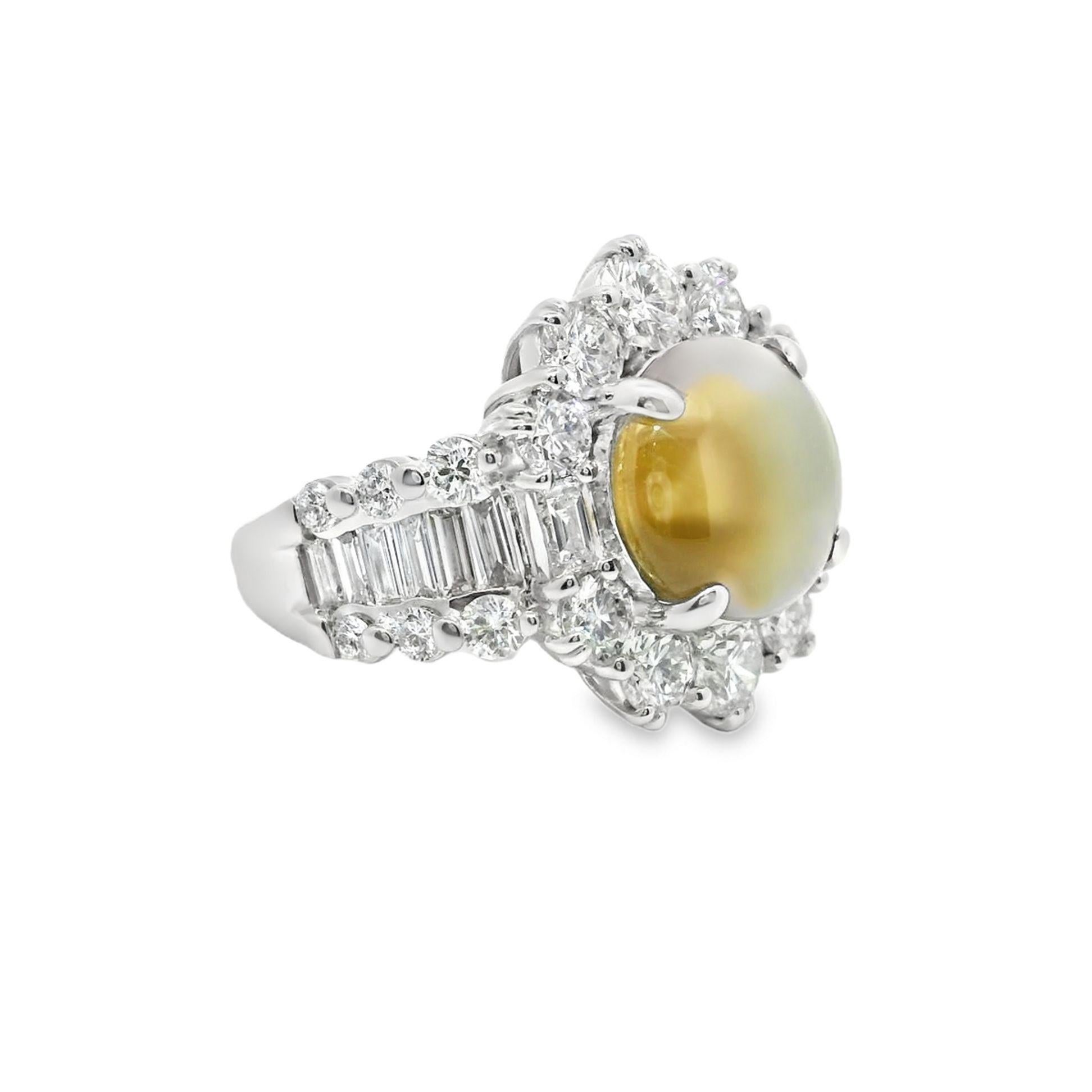 A striking and elegant ring featuring a natural cat’s eye chrysoberyl as the centerpiece, weighing 5.26 carats. The golden yellow-green hue of the chrysoberyl is beautifully highlighted by large sized mixed-cut diamonds, totaling 3.04 carats, in a