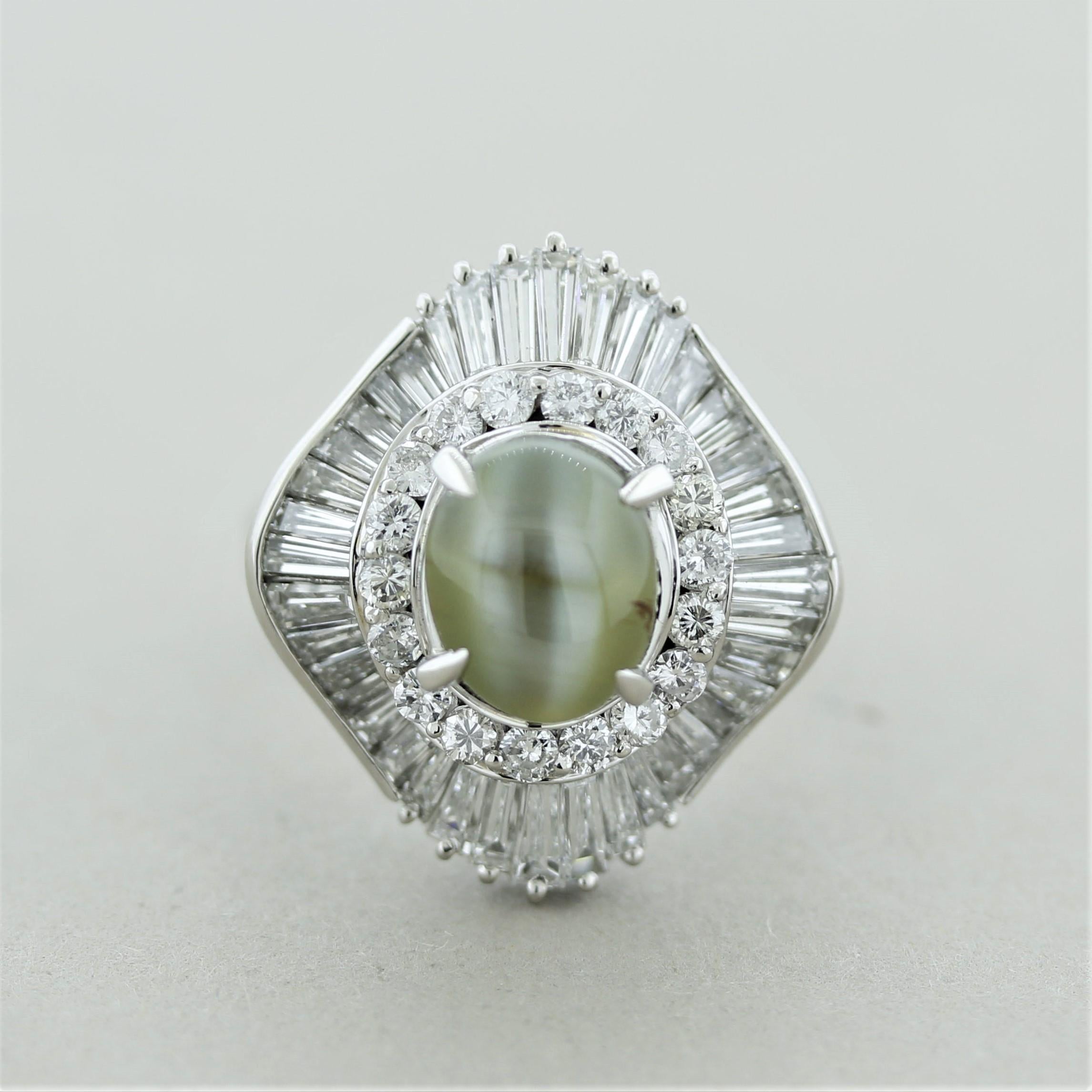 A mesmerizing cats eye ring to get lost in. The chrysoberyl weighs 3.37 carats and has the ideal classic milk and honey color along with a strong and sharp cats eye. It is surrounded by 2.59 carats of baguette and round brilliant-cut diamonds.