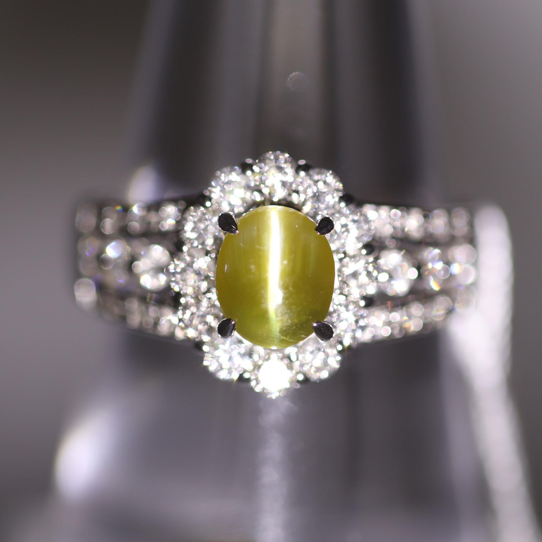 A beautiful ring featuring a sleek and sexy cats eye chrysoberyl weighing 1.33 carats. It has the ideal “milk and honey” color with a strong eye running down the middle. It is accented by 0.71 carats of round brilliant-cut diamonds which halo the