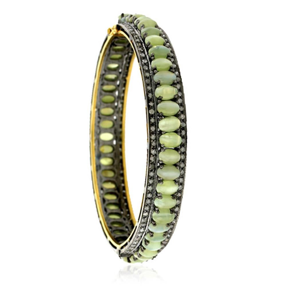 Charismatic and cool,, this Oval shape cabochon Cat's Eye and diamond openable bangle is one of a kind.

Closure: Box catch with safety hooks on side

18kt Gold: 5.72gms
Silver: 18.45gms
Diamond: 2.82cts
Cats Eye: 34.7cts
