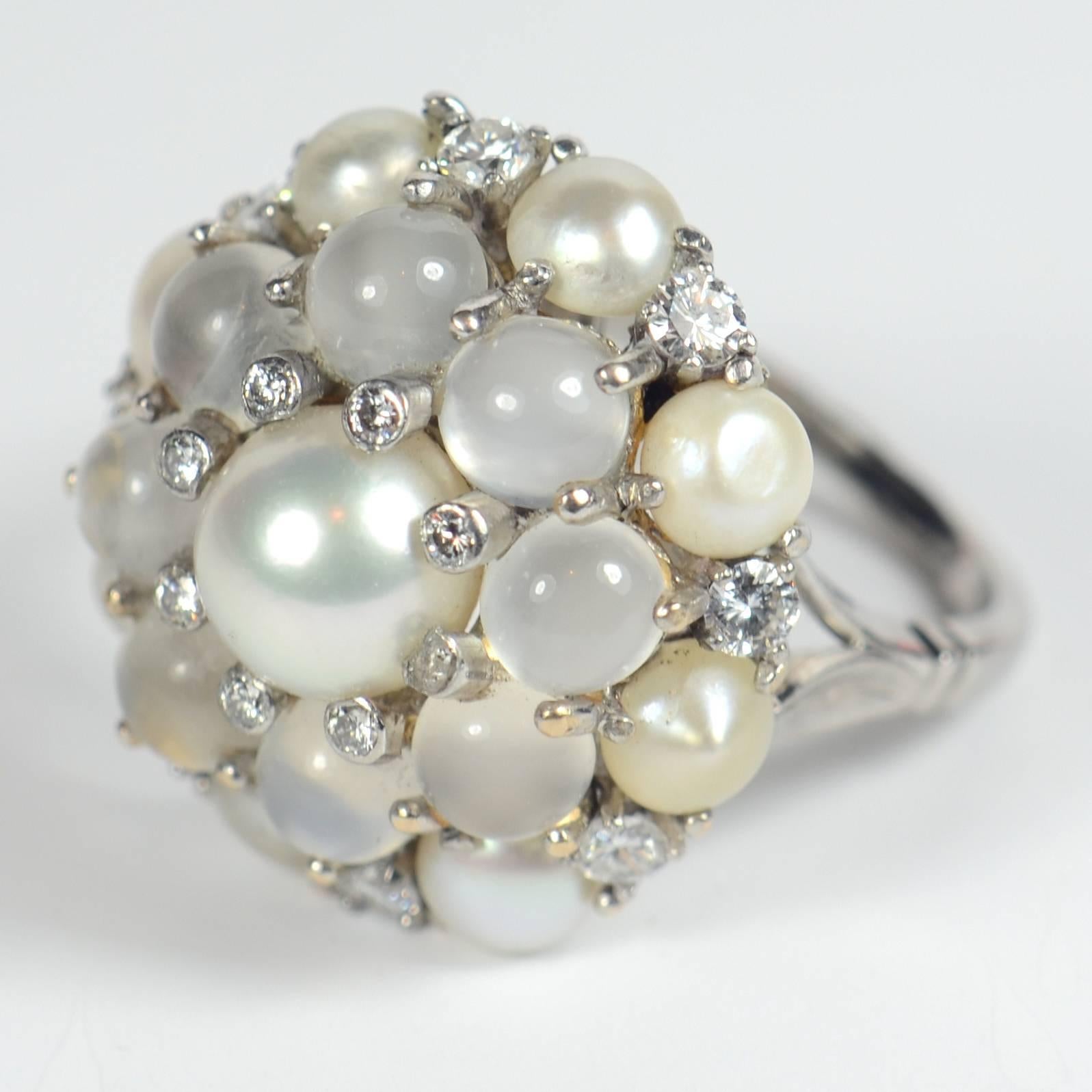 A refined white on white colour scheme gives this striking moonstone and pearl bombe ring an elegant appearance – just the thing for cocktail hour!  

The ring is marked 18ct for 18 carat white gold, and is set with 9 pearls, 8 cat’s eye moonstones