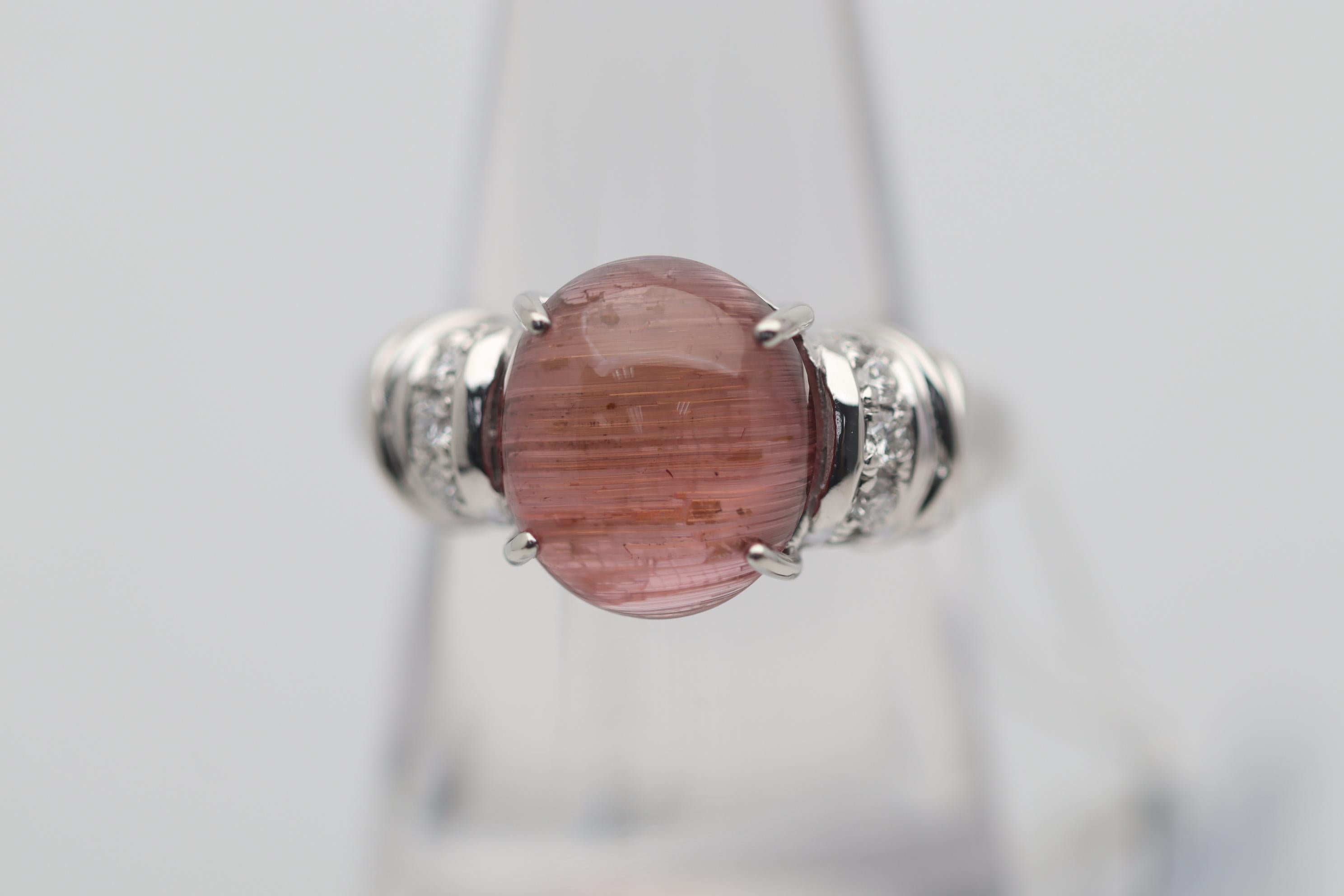 A stylish platinum made ring featuring a cabochon tourmaline with a unique phenomenon, chatoyancy! A strong and sharp cats eye can be seen running across the dome of this 4.68 carat tourmaline. It is further accented by 0.20 carats of round