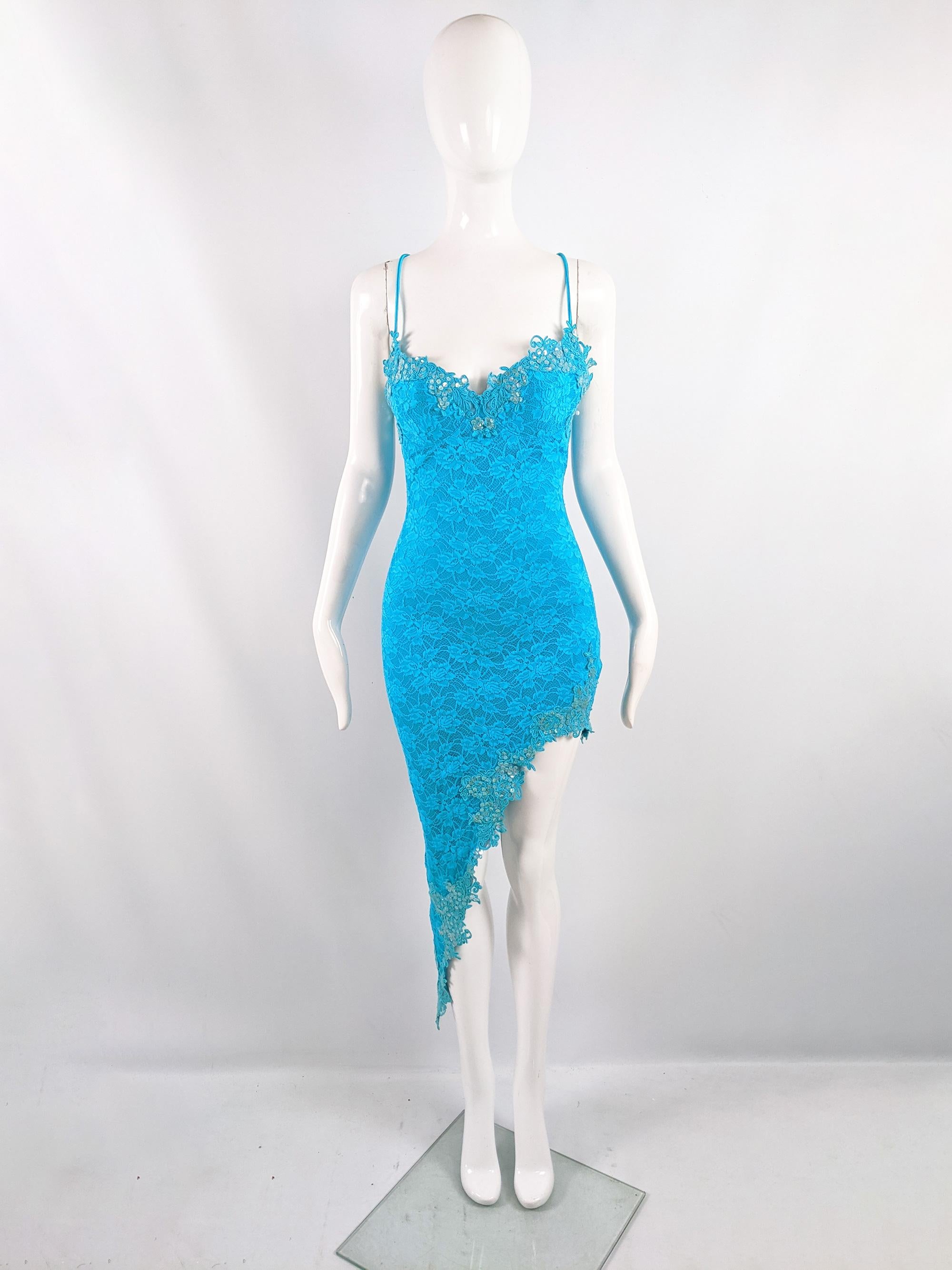 An incredibly sexy vintage womens evening dress by luxury British label, Catwalk Collection (known for their incredible corsetry and provocative eveningwear) from the early 2000s. In a turquoise blue lace with sequin embellishments, an asymmetrical