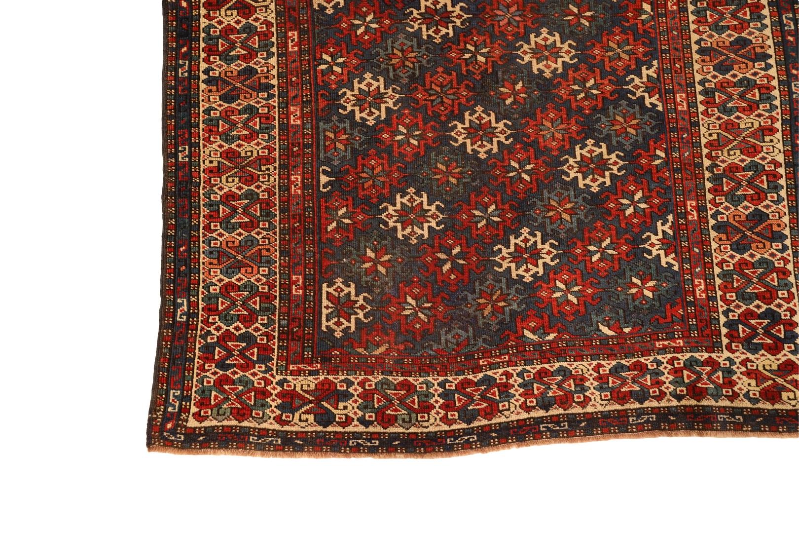 This exquisite Caucasian rug is a true masterpiece of intricate design and craftsmanship. The rug features stunning sun motifs that run diagonally in lines, creating a mesmerizing effect that draws the eye in. The lines are composed of either all