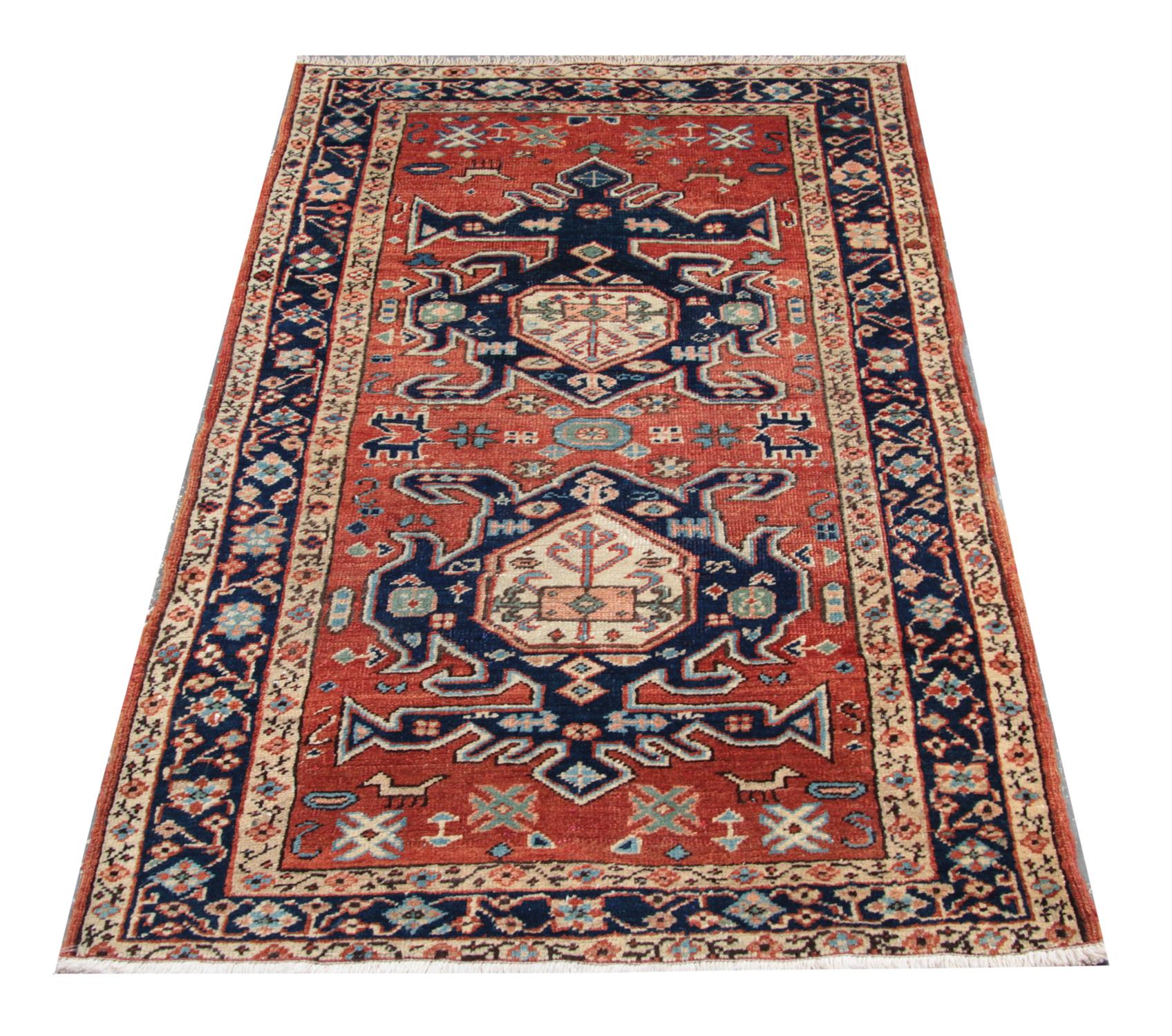 This piece is a Caucasian Antique Carpet featuring an orange central field adorned with two detailed central medallions woven symmetrically in accents of blue cream, orange and green. Intricate motifs and animal designs have been woven in the