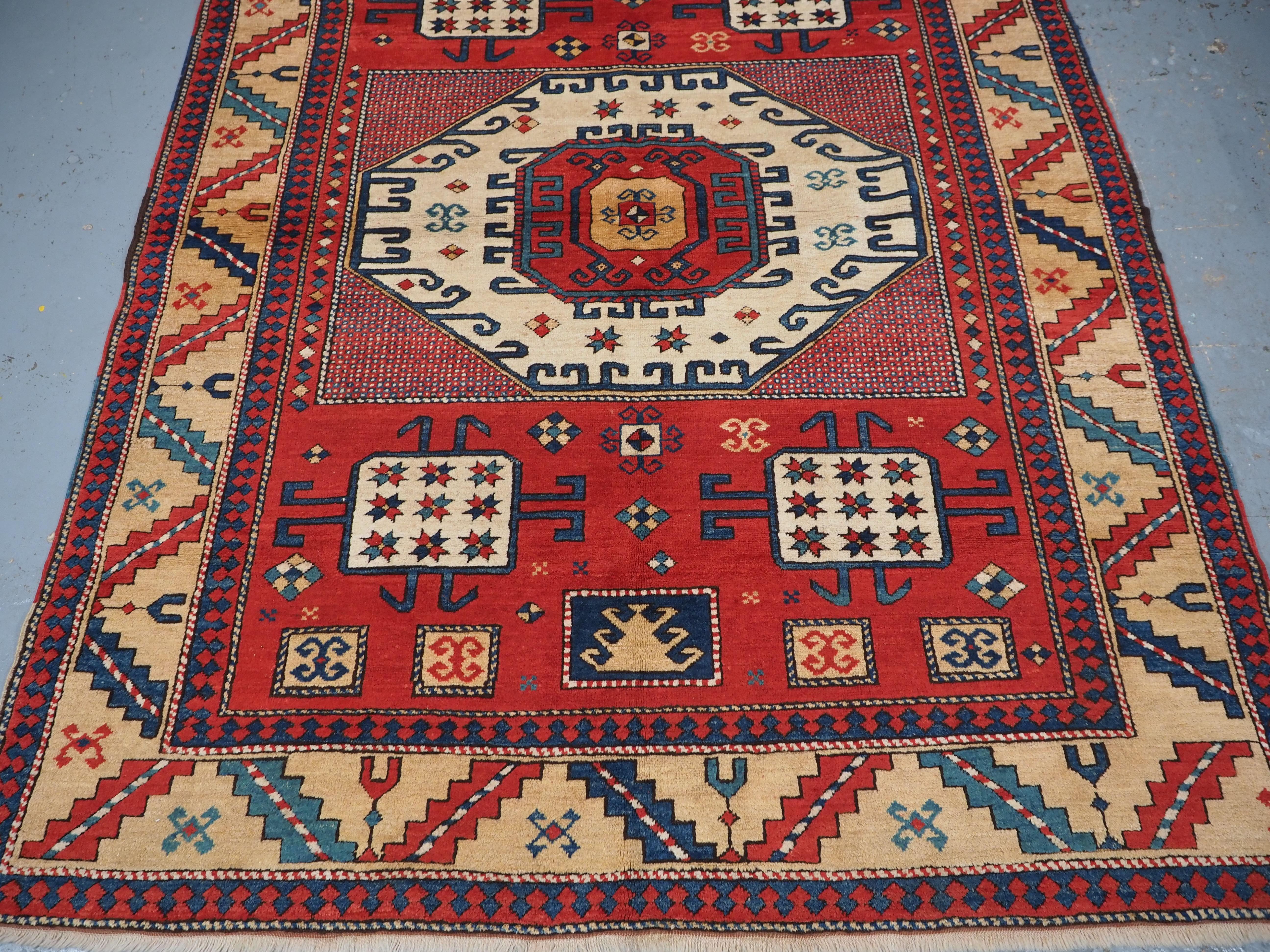 Wool Caucasian Karachov Kazak style rug of classic design on a red ground For Sale