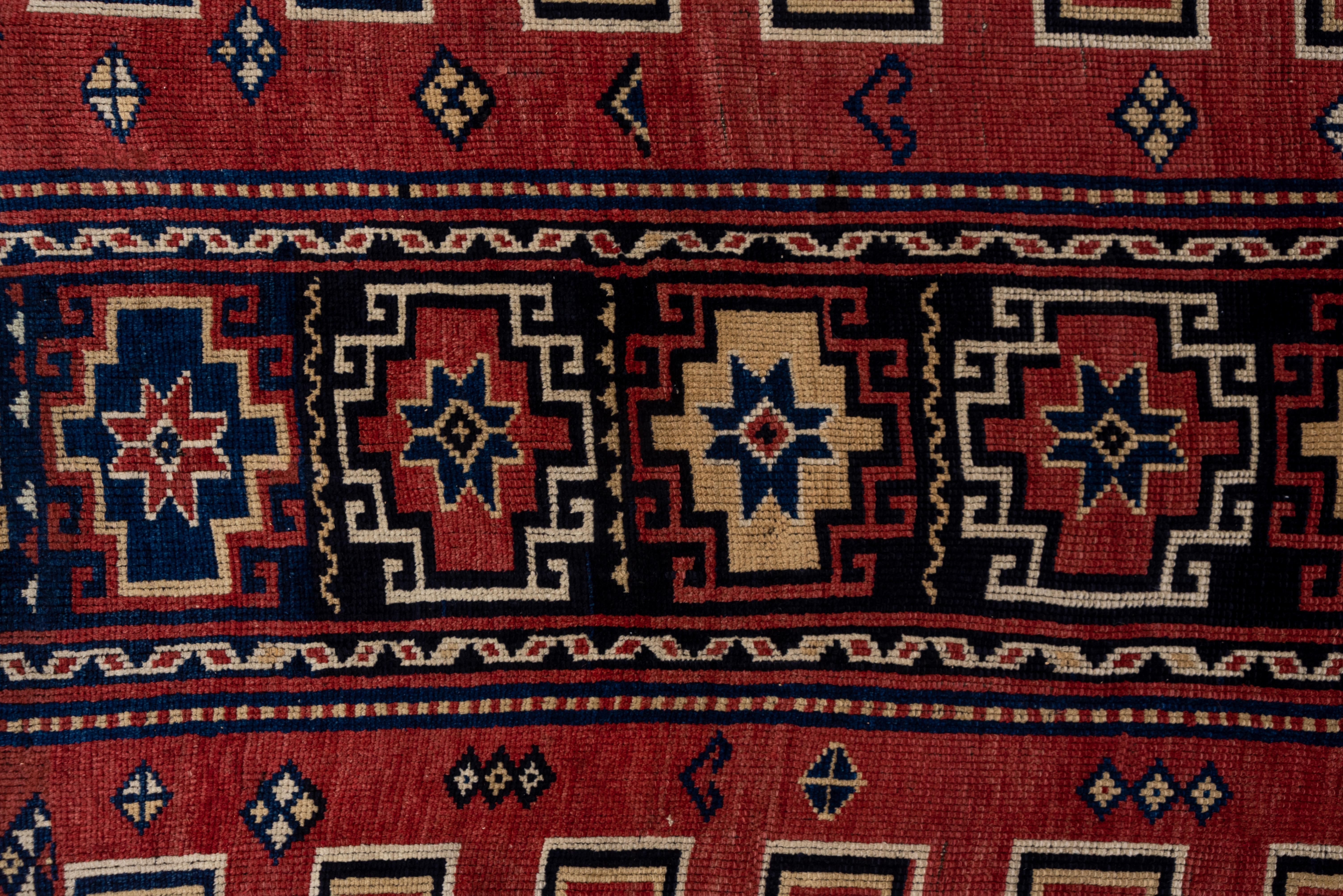Sur un fond bleu marine à noir, le sous-champ cramoisi cranté et pointu présente un cartouche bleu marine ou noir avec six guls de Memling accentués de paille, d'ivoire, de rouge et de noir. Quatre autres goules de Memling apparaissent aux cornets