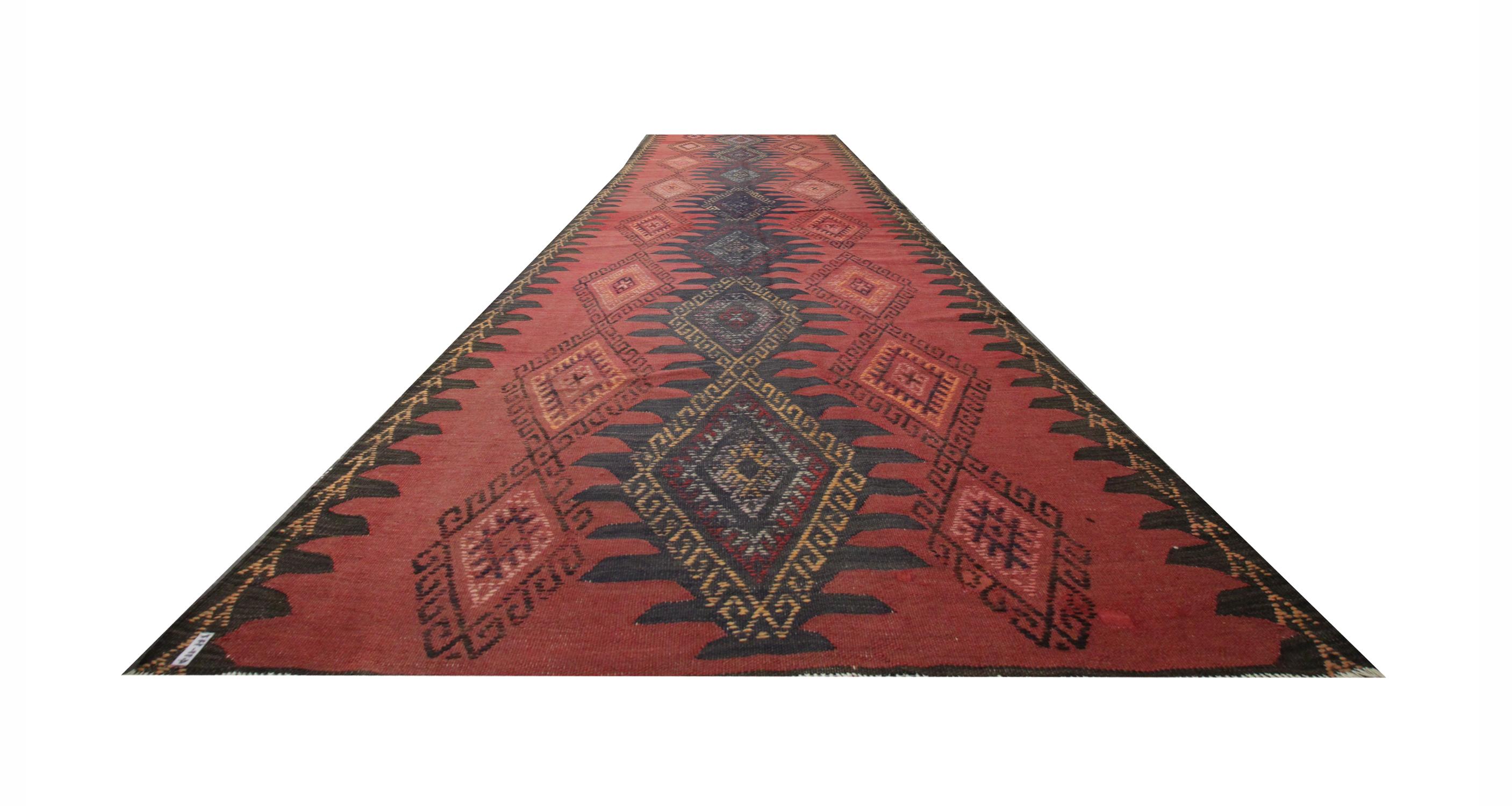 This fine wool kilim has been woven with a bold hook diamond design. The design is made up of deep blue accent colours on a rich red background. The runner rug is bordered with deep brown zig-zags with a yellow triangular pattern. The colour palette