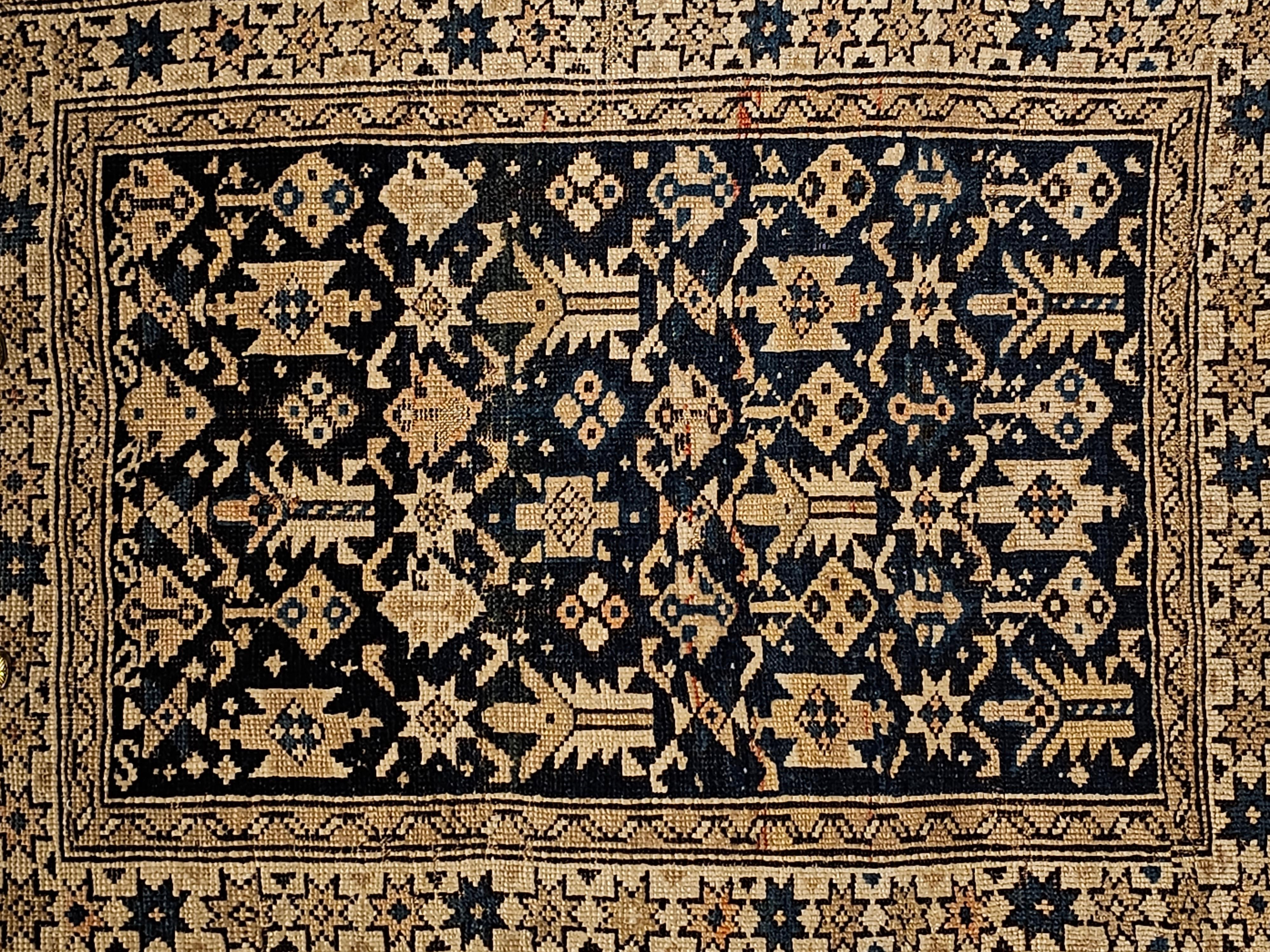 A beautiful Caucasian Shirvan area rug in allover design in abrash navy blue and ivory with design accent colors of pale yellow, French blue circa the 1880s.  The rare small Shirvan rug could have been woven to be used as a bagface or a prayer rug. 