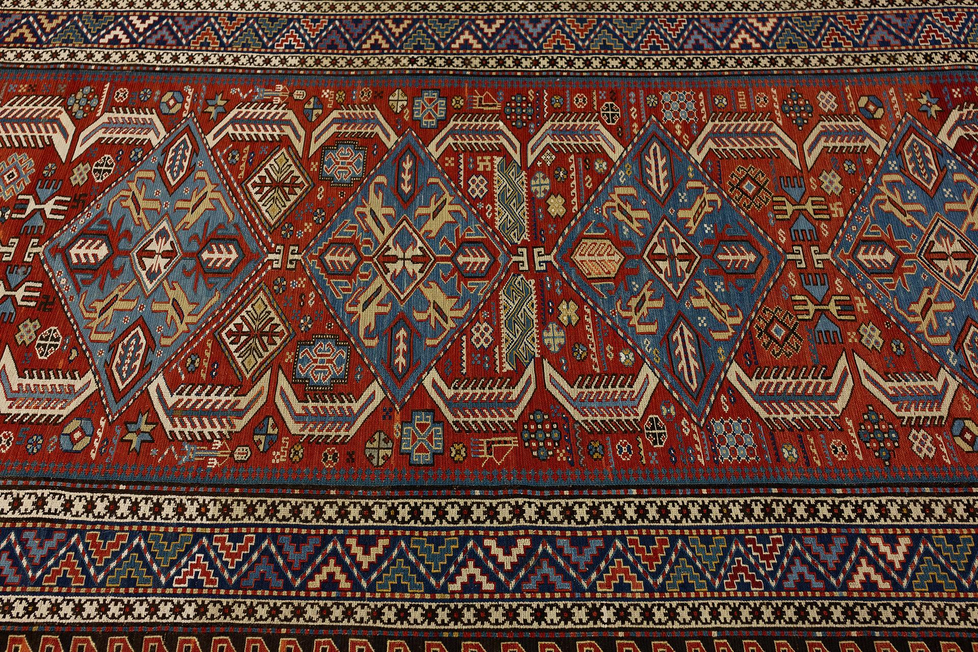 This exquisite Caucasian Sumak rug, measuring 252 x 121 cm, is a stunning showcase of intricate craftsmanship and rich cultural heritage. The vibrant colors and elaborate patterns reflect the traditional artistry of the Caucasus region, making this