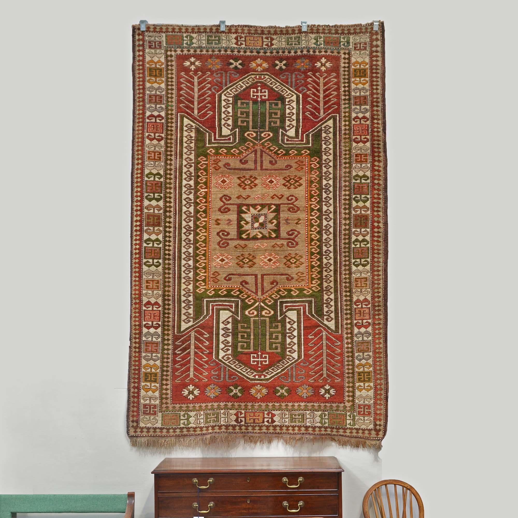 Kaukasus-Kazak-Teppich mit Hakenmedaillons
Das geometrische Design der Südkaukasus-Region mit dem für das kasachische Design typischen Hakenmedaillon.   Rostroter Grund mit einem großen zentralen Medaillon in Form eines Vogels, 7 Blumenmedaillons an