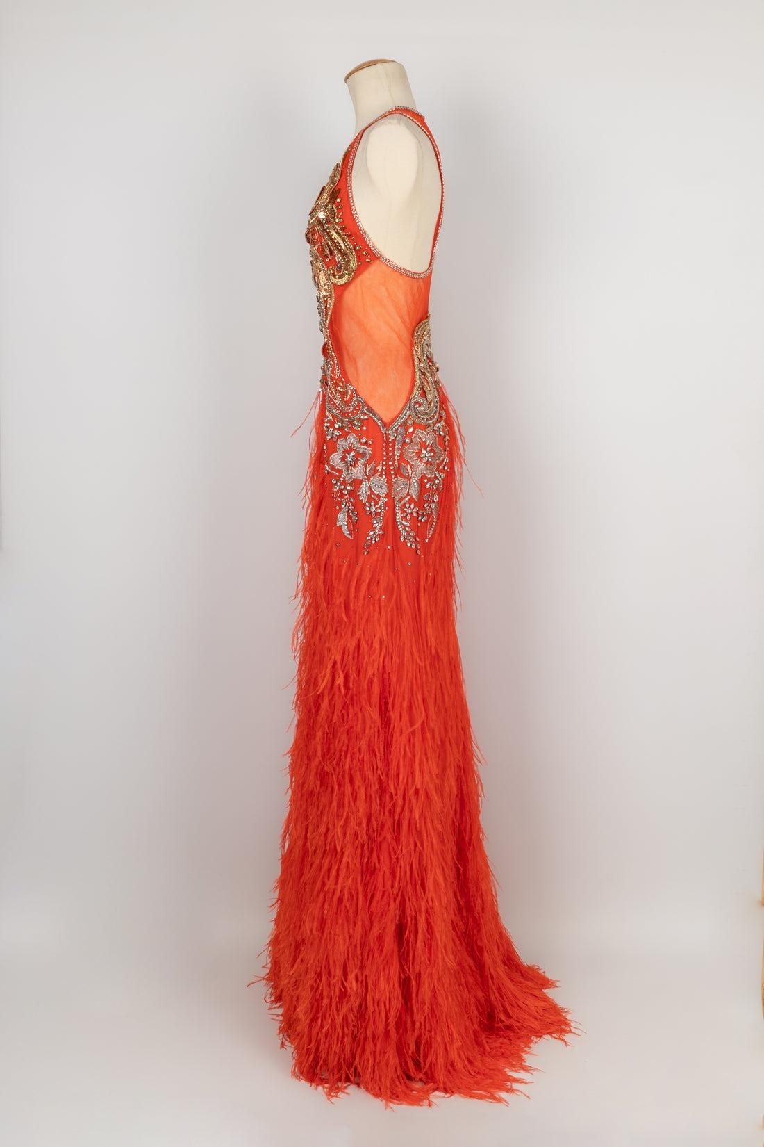 Cavalli - Long orange tulle dress embroidered with pearls, sequins, and golden threads. It is also sewn with feathers. No size nor composition label, it fits a 36FR.

Additional information:
Condition: Very good condition
Dimensions: Chest: 40 cm -