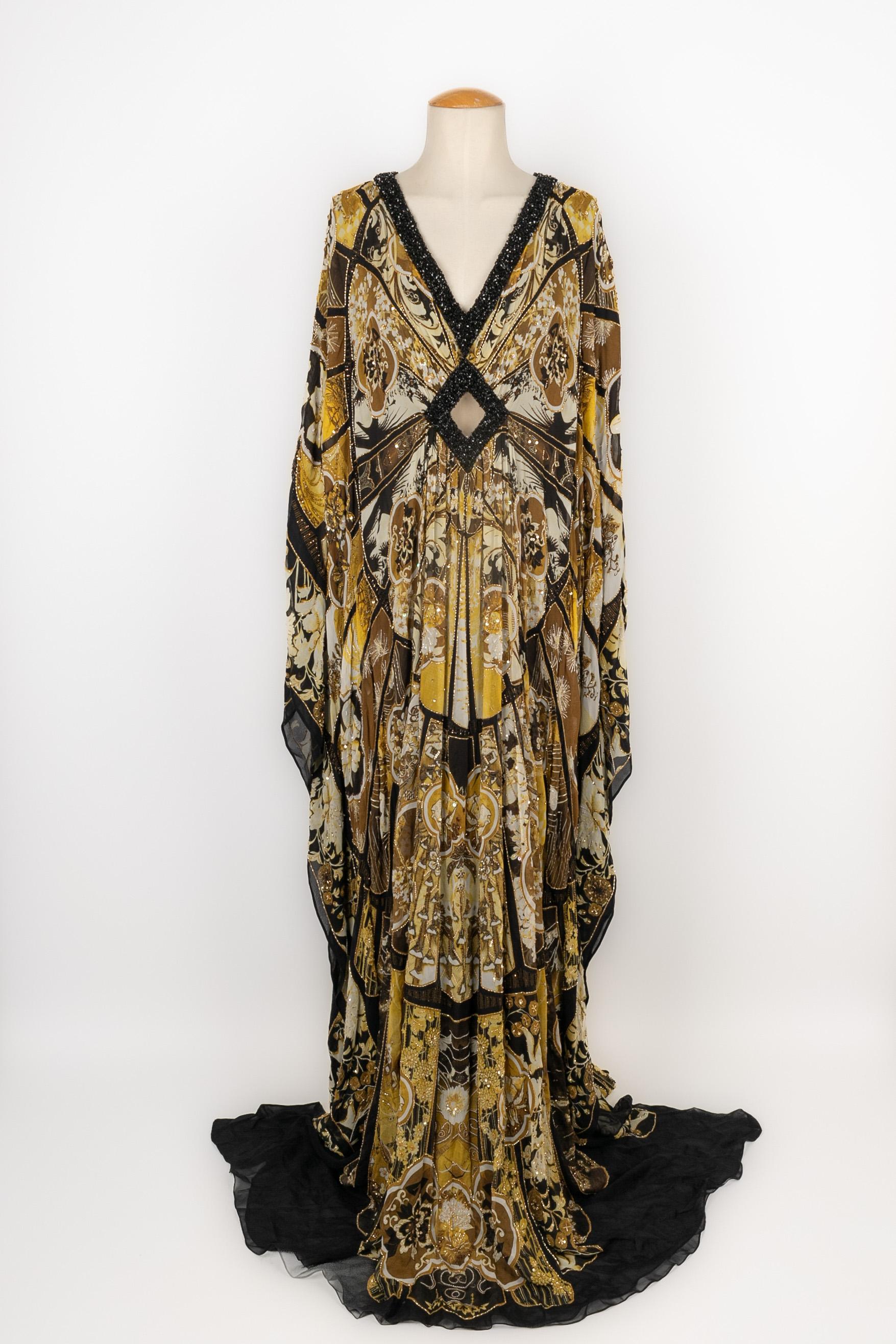 CAVALLI - Vestido largo de caftán de seda amarillo, negro y blanco estampado con bloques de flores rematados con perlas doradas. Vestido con cuello en V. Falta la etiqueta de la talla, se ajusta a una 38FR.

Estado:
Muy buen