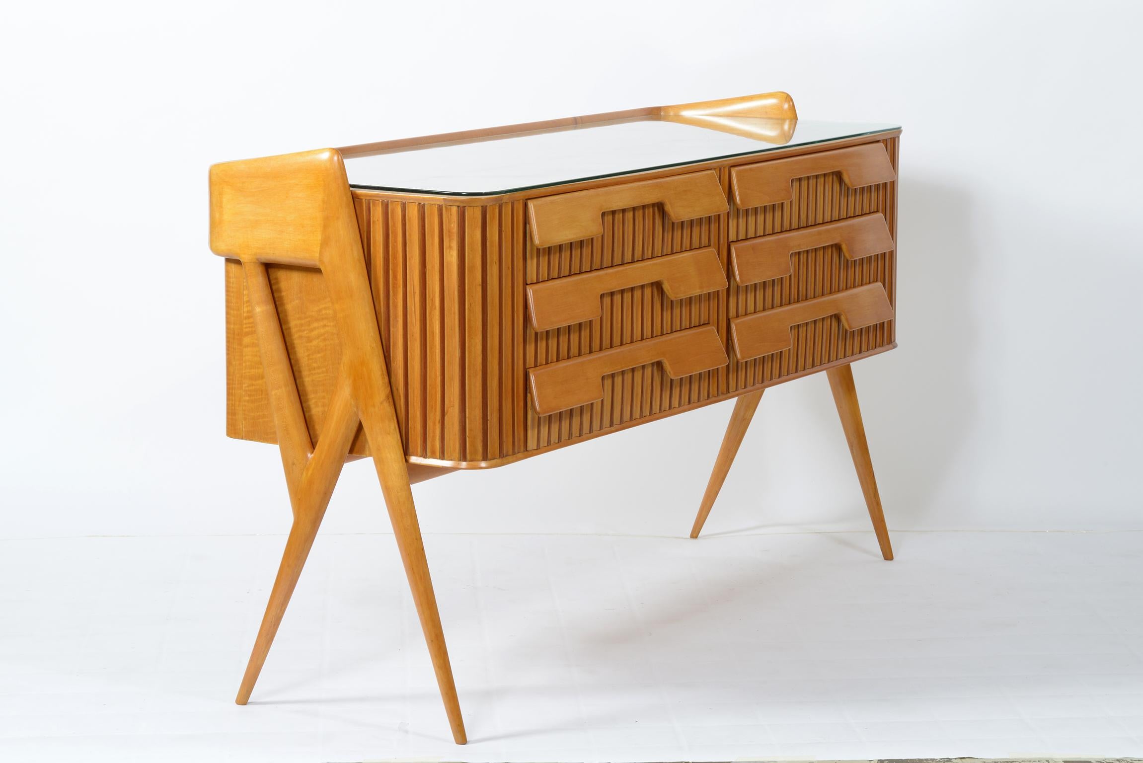1950s Italian chest of drawers designed and produced by Manufacture Cavatorta Roma in solid maple carved grooved body with six protruding sculpted drawers to make decoration and handle. The four very thin legs that end in a pointed shape make this