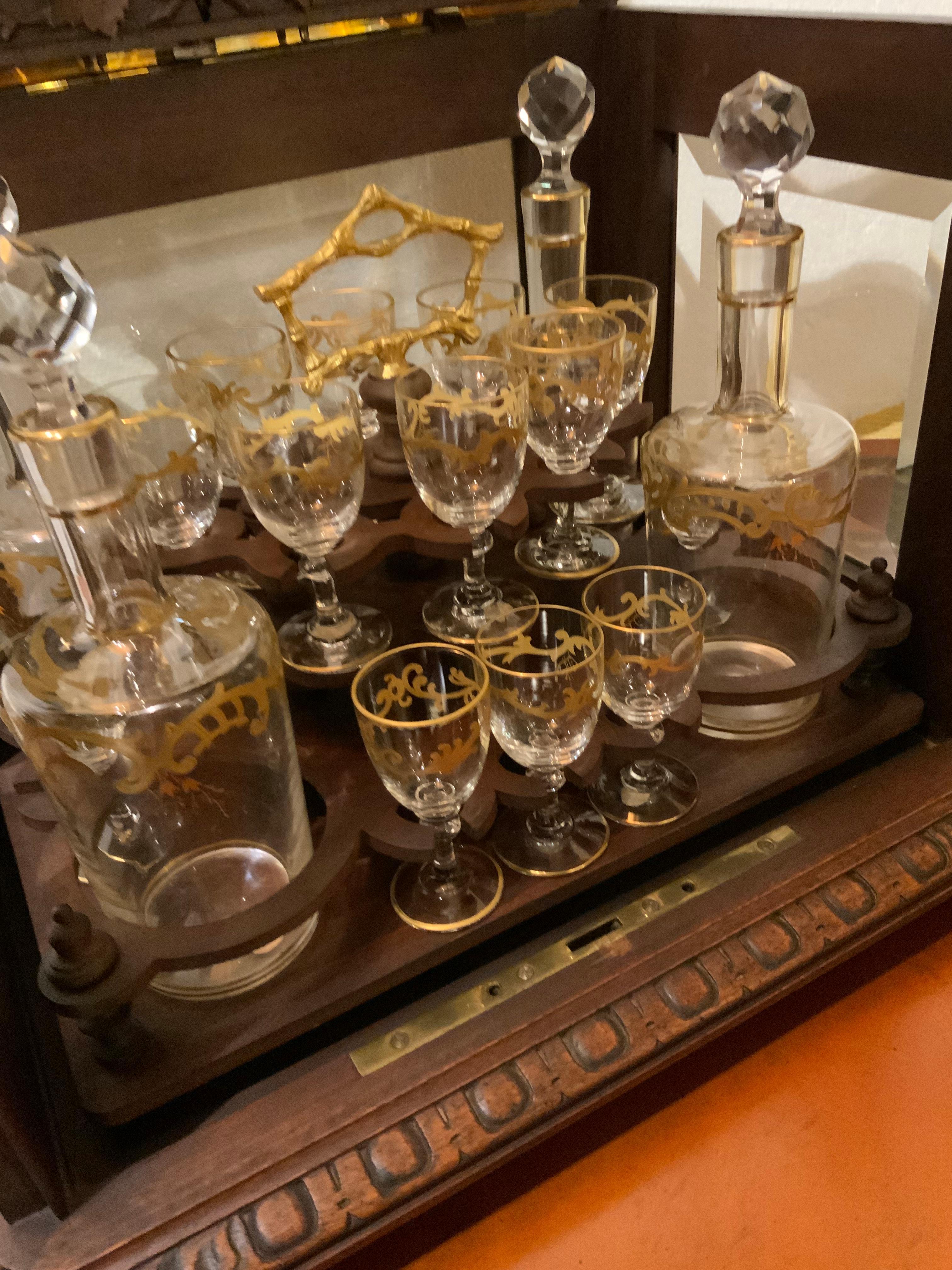 This cave a liqueur set is truly special because the box is exquisitely 
Carved and has the original beveled glass. The decanters and stem
Ware are by St. Louis and the original label is attached on the bottom 
Of the decanters. The stems are