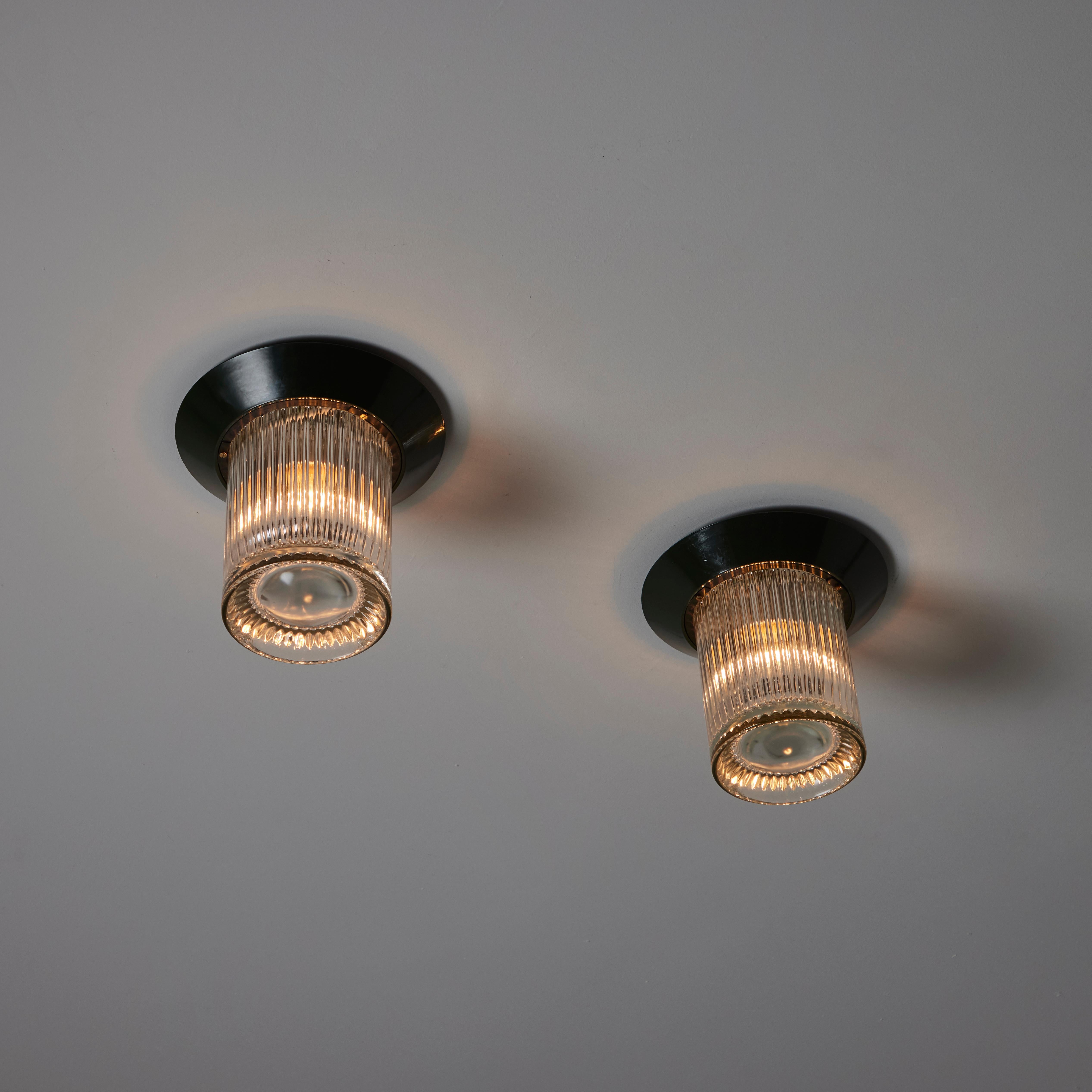 Montaluce 'Cavea' di Angelo Mangiarotti per Artemide. Progettato e prodotto in Italia, intorno agli anni '1970. Vetri cilindrici con bordi a rilievo accoppiati a piastre di montaggio smaltate color verde bosco. Ogni lampada è dotata di una presa