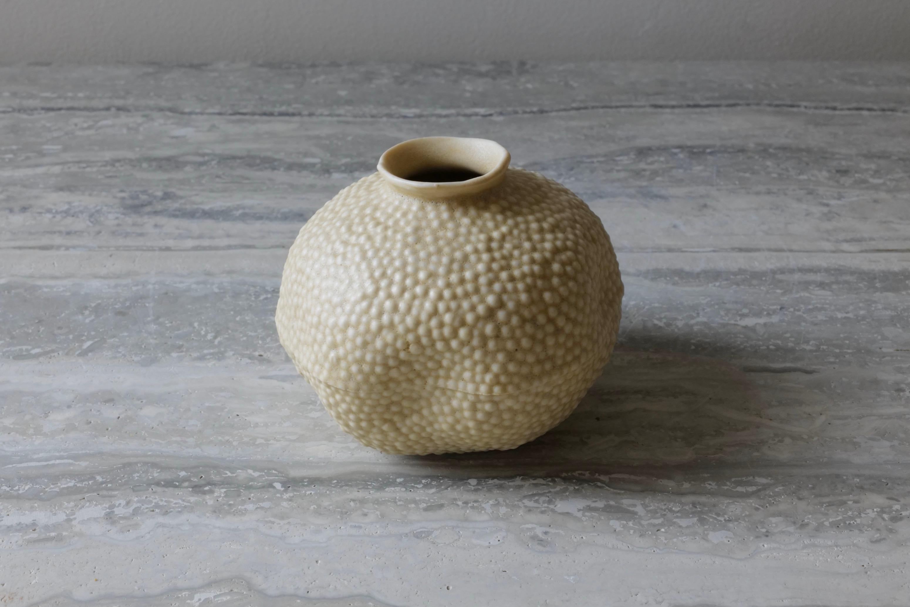 This modern and sweet bud vase is a perfect addition to any corner of the room. Hand-cast in porcelain using a mold hand-carved by the artist. The final glazing is a beautiful earthen color with a slightly matte finish, in line with the natural