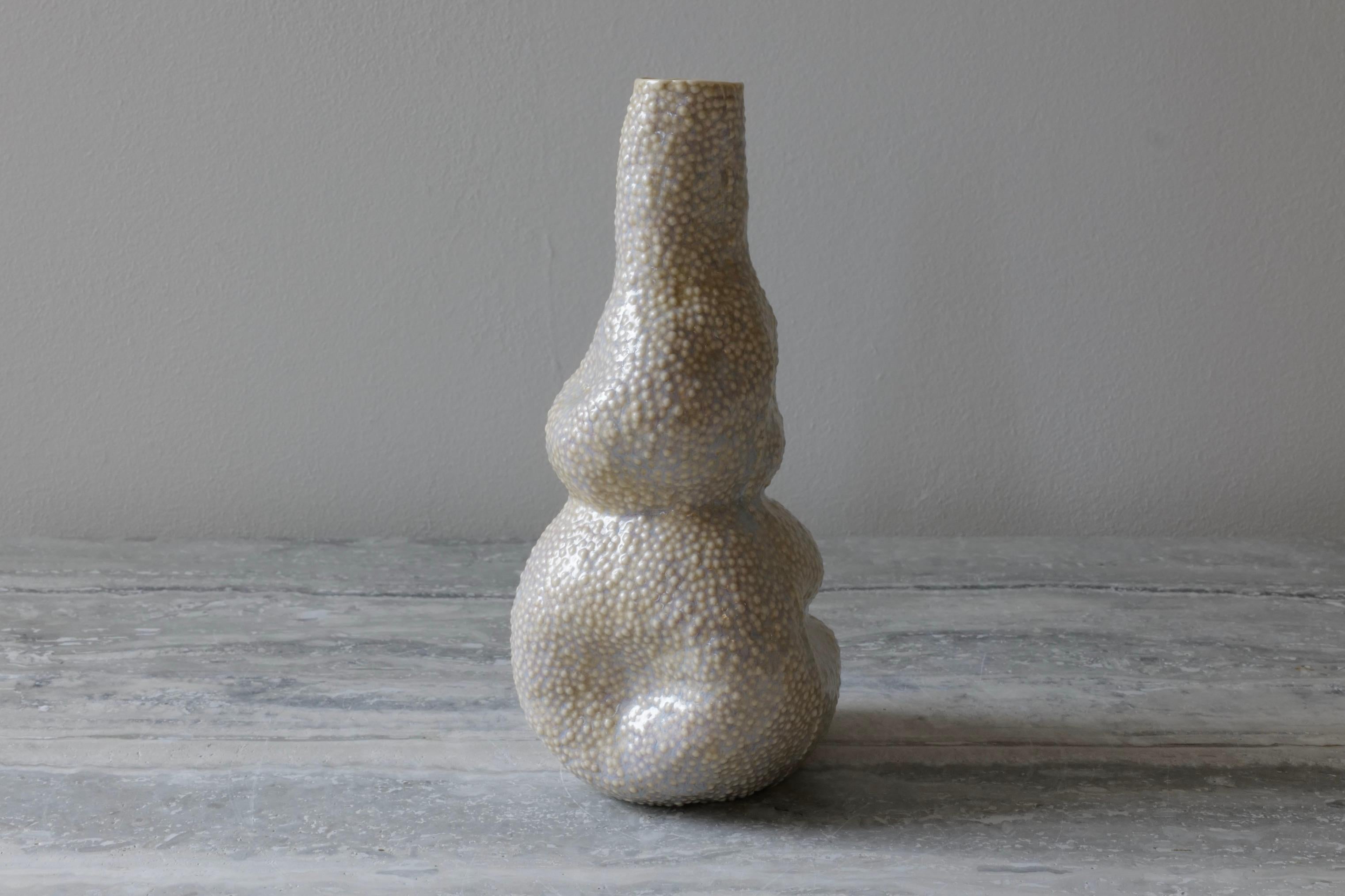 This organic looking vase is the perfect addition to any corner of the room. The asymmetrical quality of the vessel adds life and movement to any space. Hand-cast in porcelain using a mold hand-carved by the artist. The glaze is a beautiful glossy