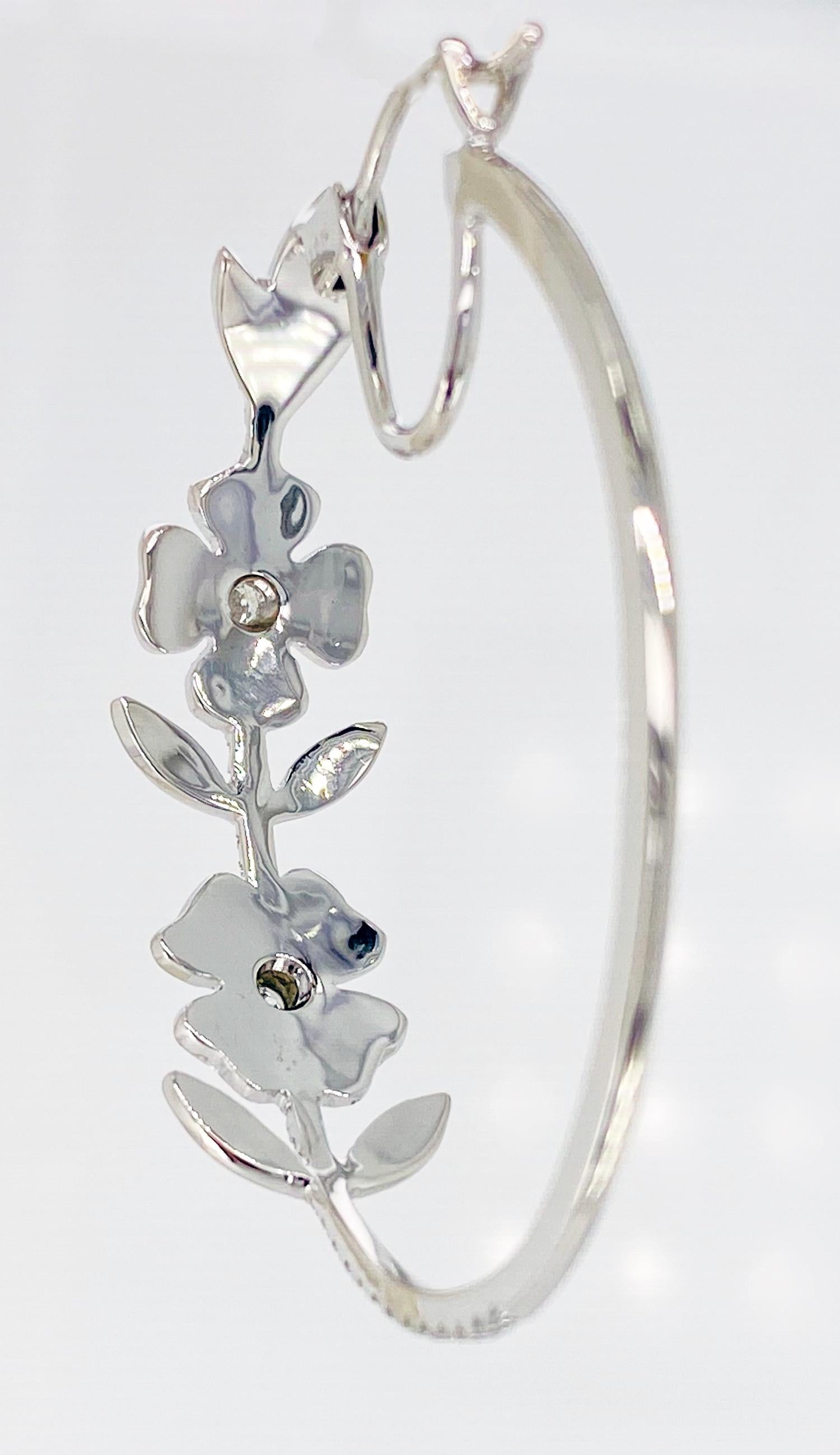 Designed by Cayen Collection, these very pretty and feminine Flower Hoops contain 1.06 carats of fully faceted, round brilliant Diamonds.  They are a flattering elongated oval shape, with a securely locking post back.
18k white gold.

#150-016