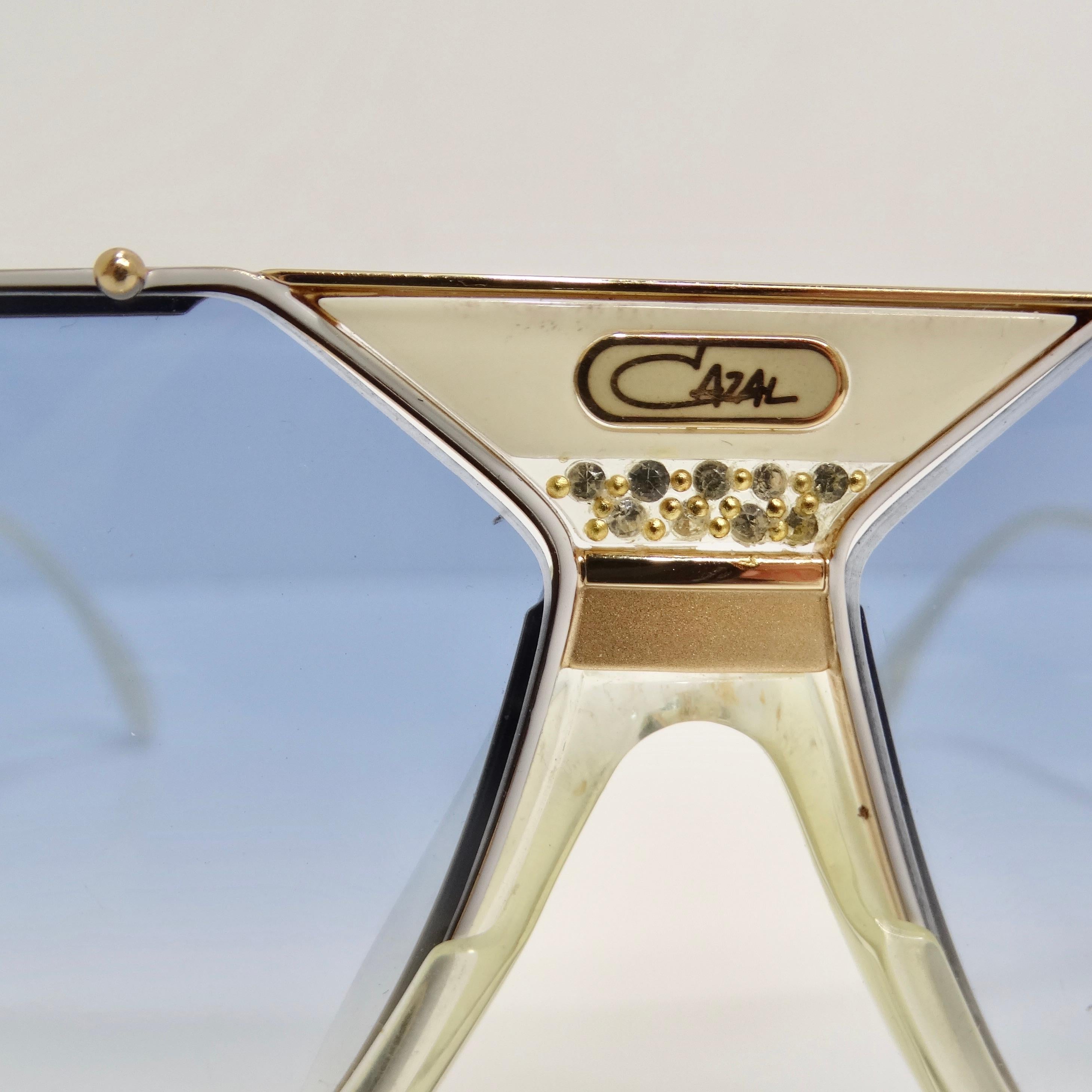 Voici les lunettes de soleil Cazal 951 Blue Gradient 1980s, un accessoire d'inspiration vintage qui allie élégance intemporelle et style affirmé. Fabriquées avec une attention méticuleuse aux détails, ces lunettes de soleil présentent un design