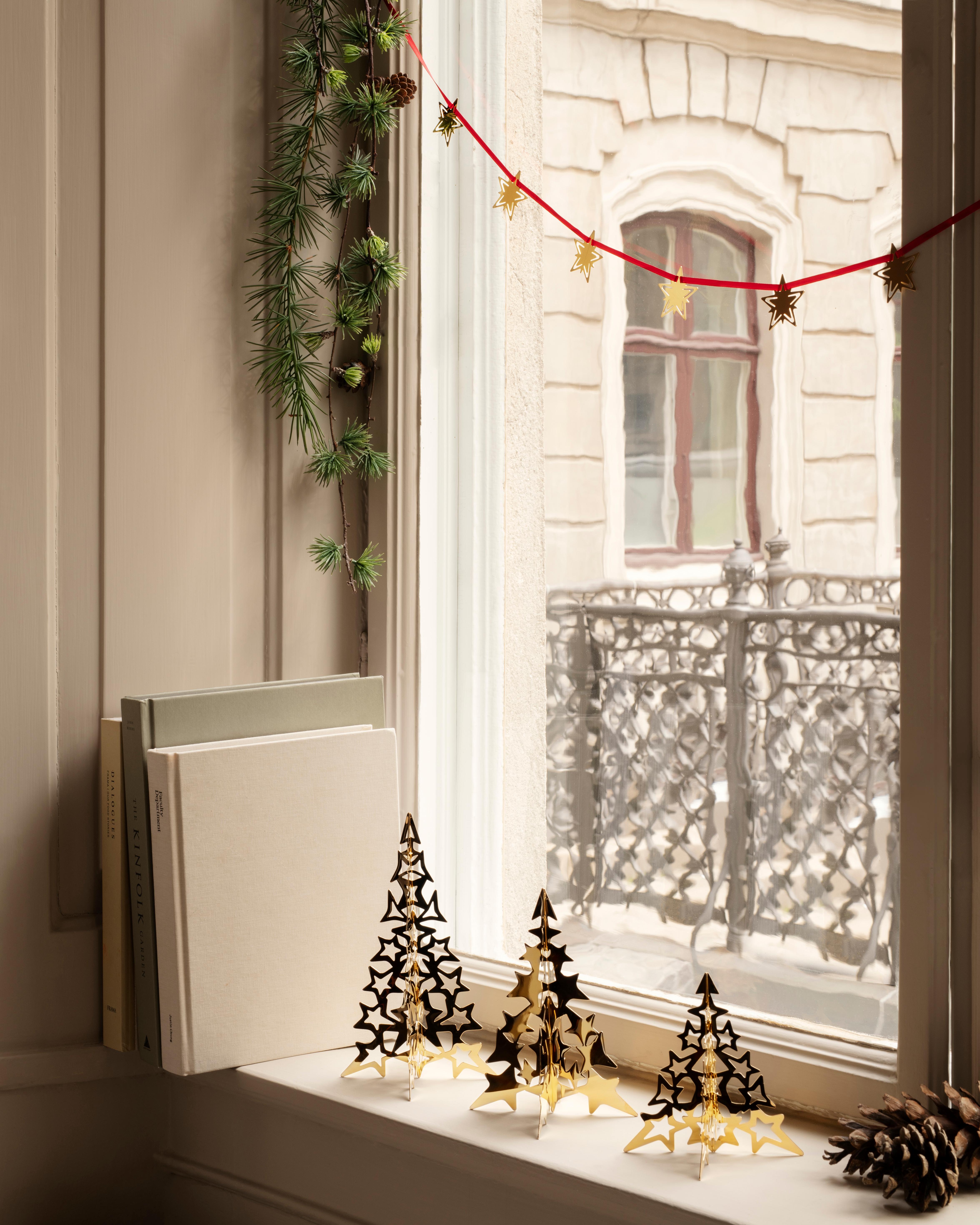 A contemporary tree made entirely from a constellation of cut-out shooting stars, this festive decoration is the perfect centerpiece to a table at Christmas time. The 18 karat gold plated surface reflects candle light creating a piece of sparkling
