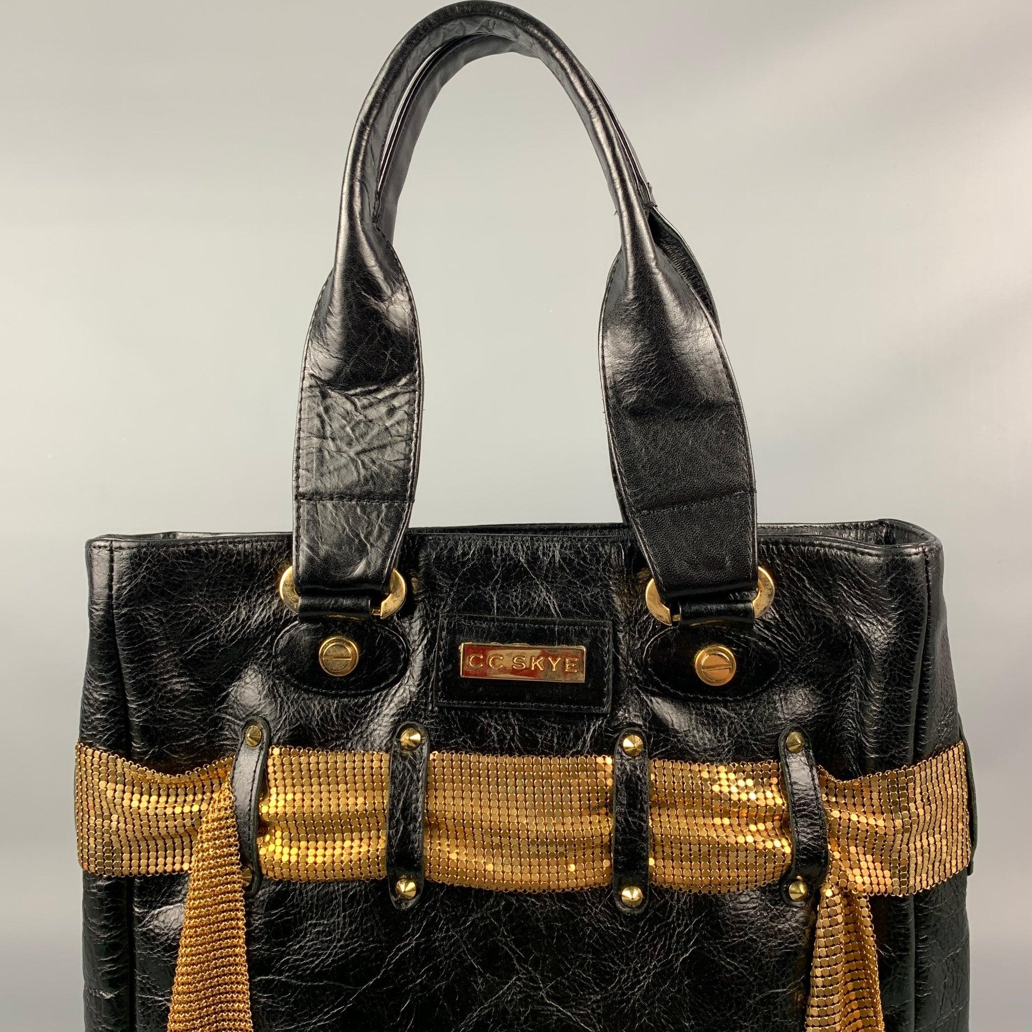 CC SKYE handbag comes in a black leather featuring a gold tone mesh belt detail, tot style, top handles, and a zipper closure.
 Good
 Pre-Owned Condition. 
 

 Measurements: 
  Length: 12.5 inches Width: 3 inches Height: 13 inches Drop: 9 inches 
 