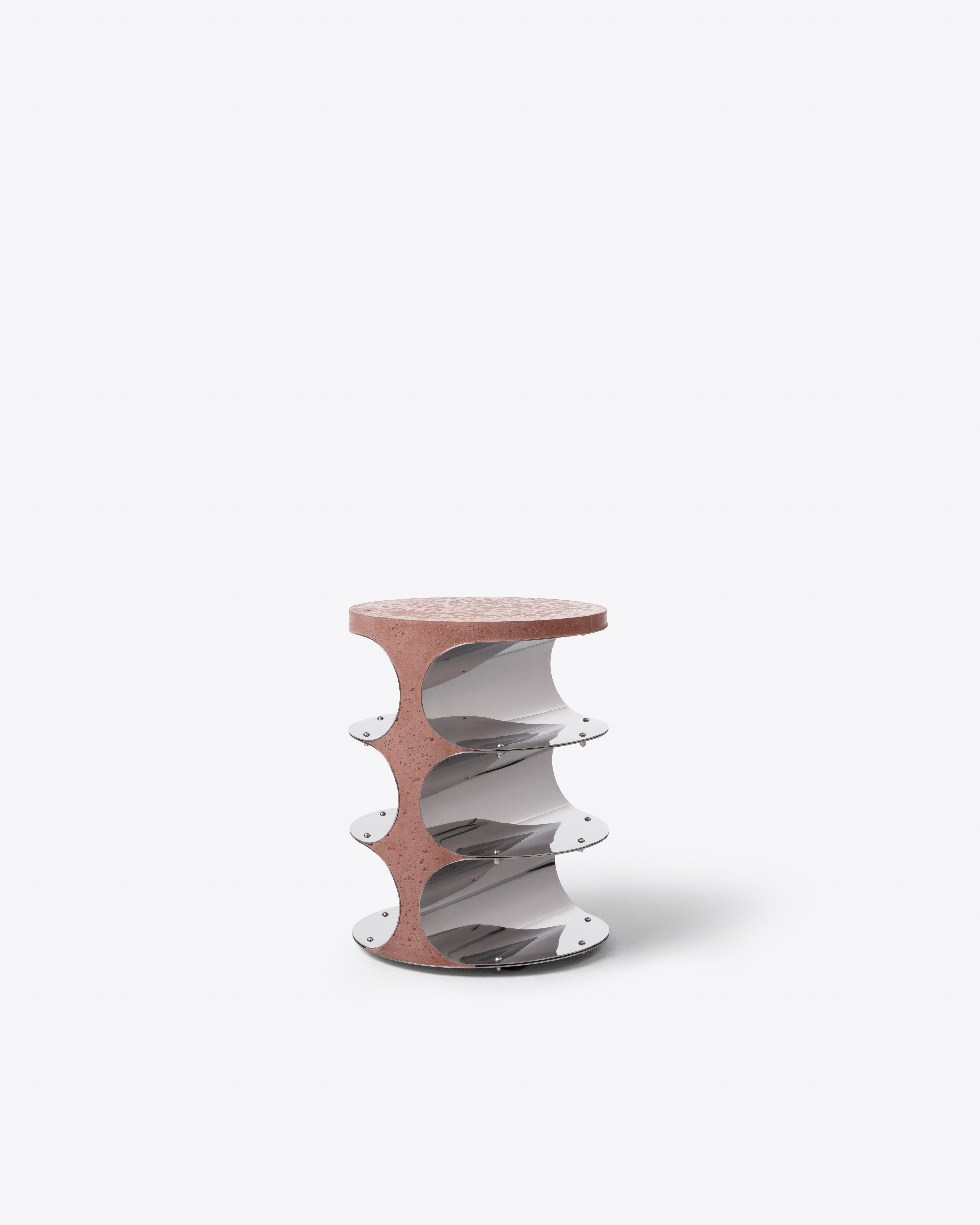 This cylindrical side table is built in stacked symmetry, balancing solidity with reflection. Exposed bolts highlight its constructive logic, while the round form suggests rotation and modular growth. A precise sculptural volume with
architectural