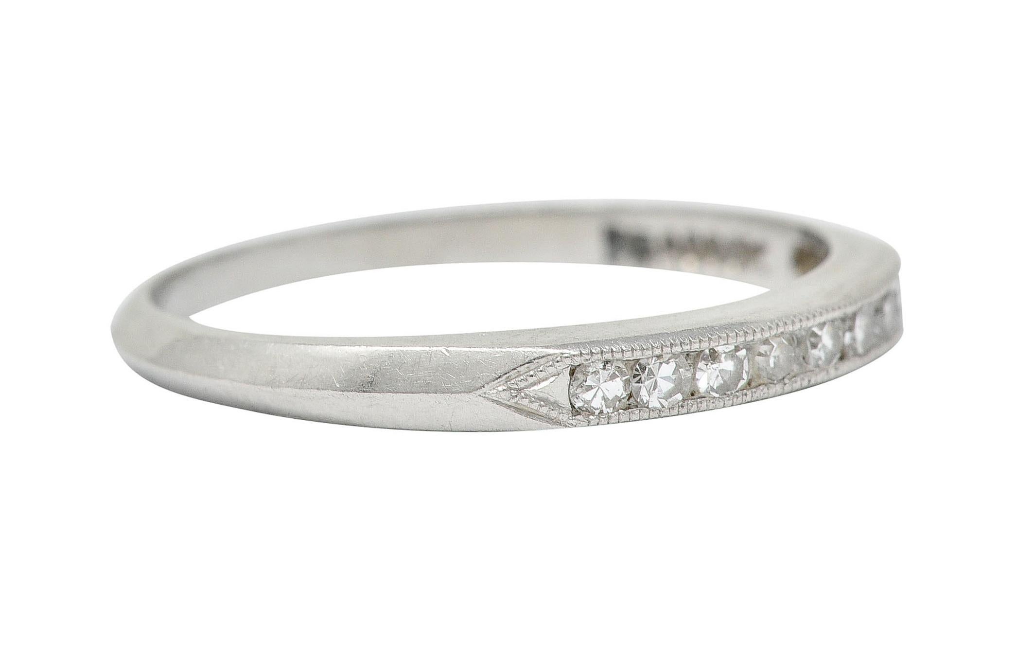 Band ring is channel set to front by single cut diamonds

Weighing in total approximately 0.18 carat - eye clean and white

Completed by pointed shoulders, milgrain edges, and a subtle knife edge shank

Stamped for platinum

Maker's mark for C.D.