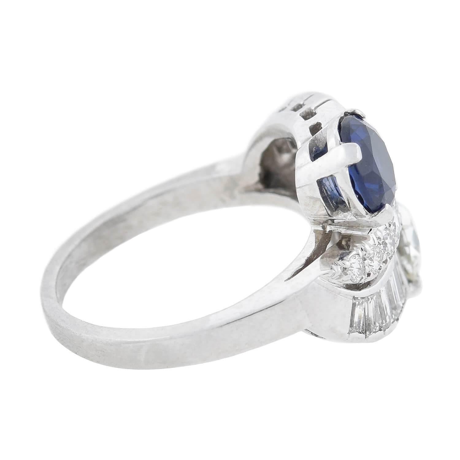 A spectacular late Art Deco (ca1930s) era diamond and sapphire ring from C. D. Peacock, an acclaimed Chicago jeweler. Crafted in platinum, this fabulous piece boasts a wonderful symmetrical bypass design adorned with brilliant gemstones. A