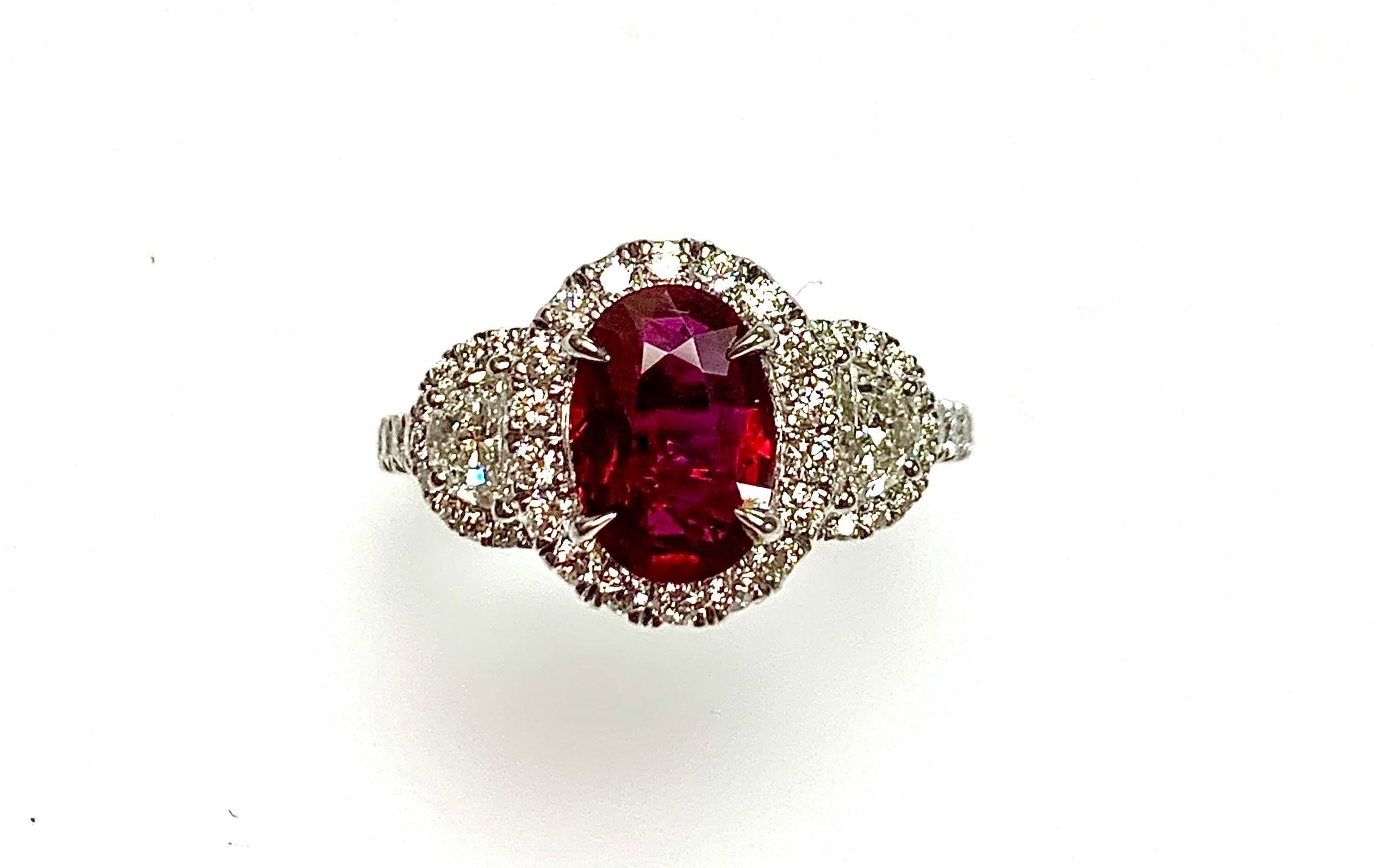 1.52 Carat oval Mozambique Ruby certified by CDC lab set in 18k white gold ring with 0.96  Carat round diamonds around it as well half moon diamonds .