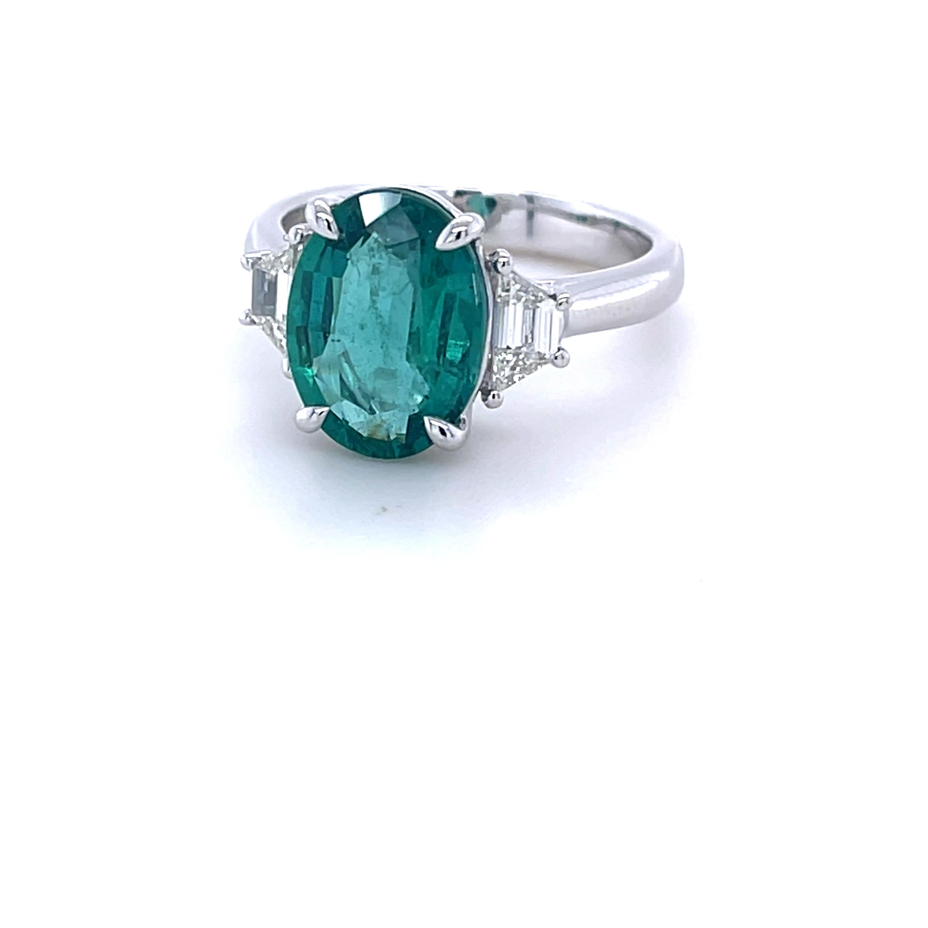 CDC Certified Oval Zambian Emerald weighing 3.05 carats
Measuring (11.81x8.73x4.78) mm
Two trapezoid diamonds weighing .37 carats
Set in platinum