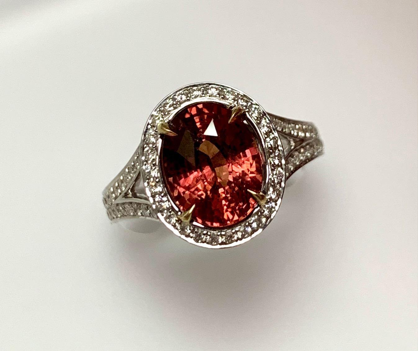 4.16 Carat Natural No heatoval shape  orange sapphire set in 18kw ting with 0.49 carat pave set diamonds arround and ha;f way on the split shank .