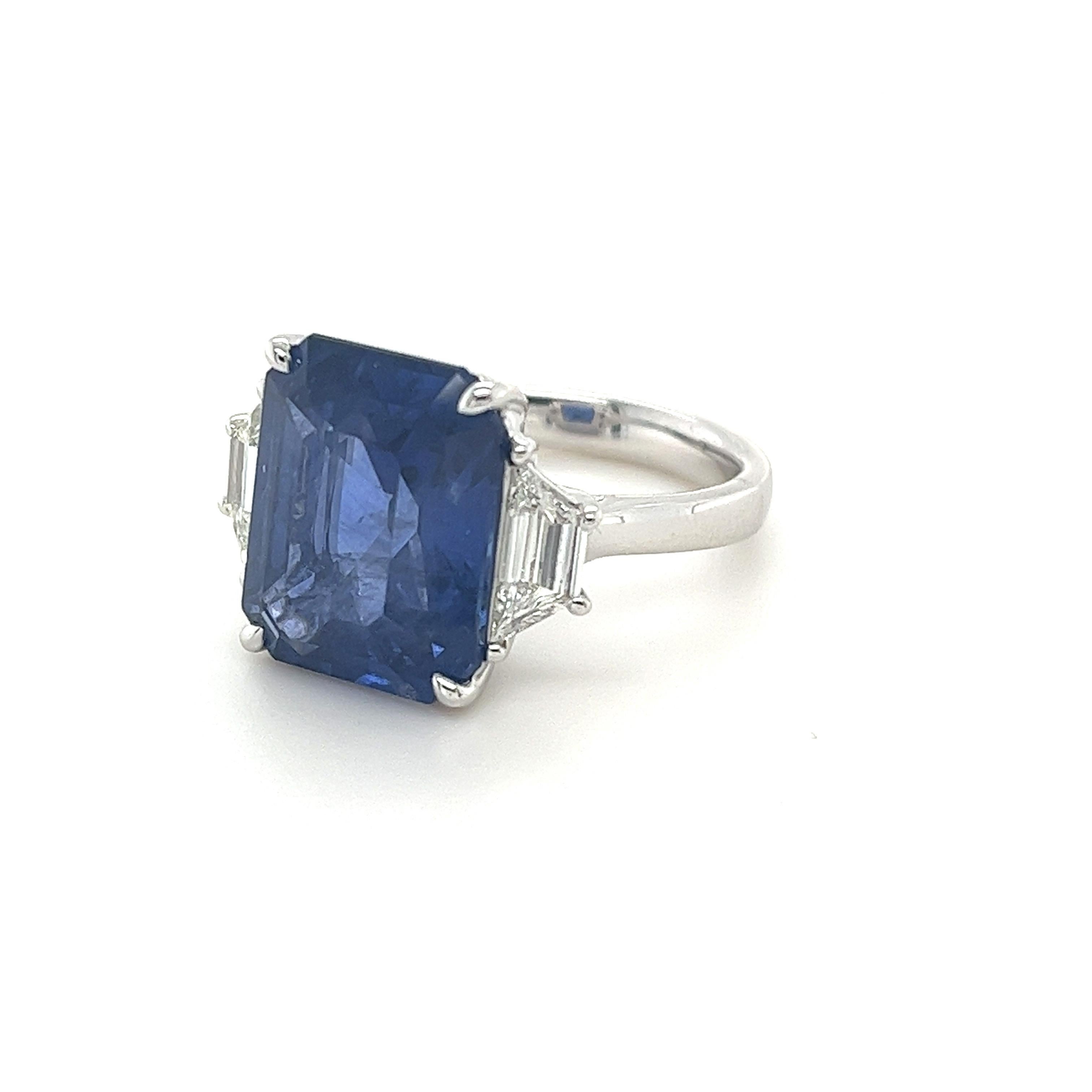 Certified Emerald Cut Ceylon Sapphire weighing 10.98 carats
Measuring (14.33x11.39x6.64) mm
Trapezoid Diamonds weighing .74 carats
H-VS
Set in Platinum Ring
10.28 g
