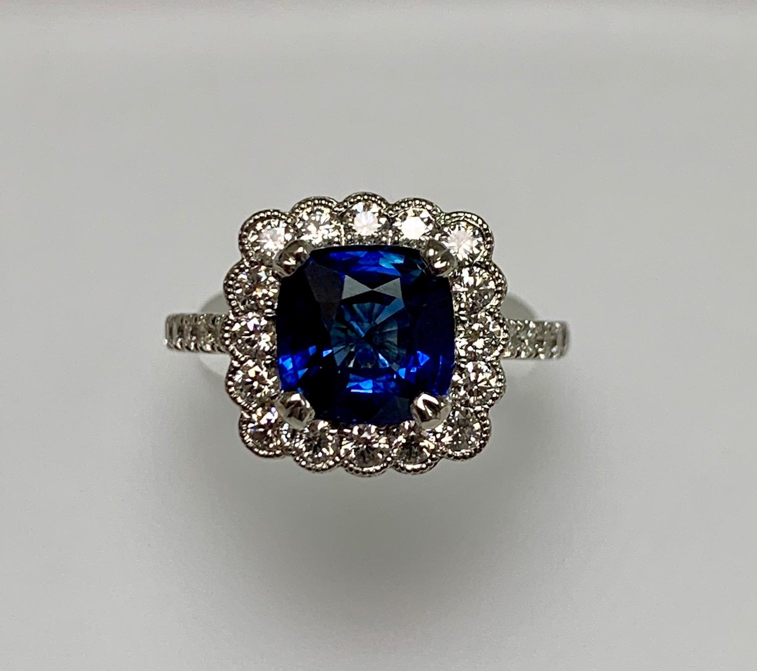 3.21 Carat Cushion Shape Blue sapphire set in 18kw gold ring surrounded with 0.76 ct diamonds around and half way on the shank.