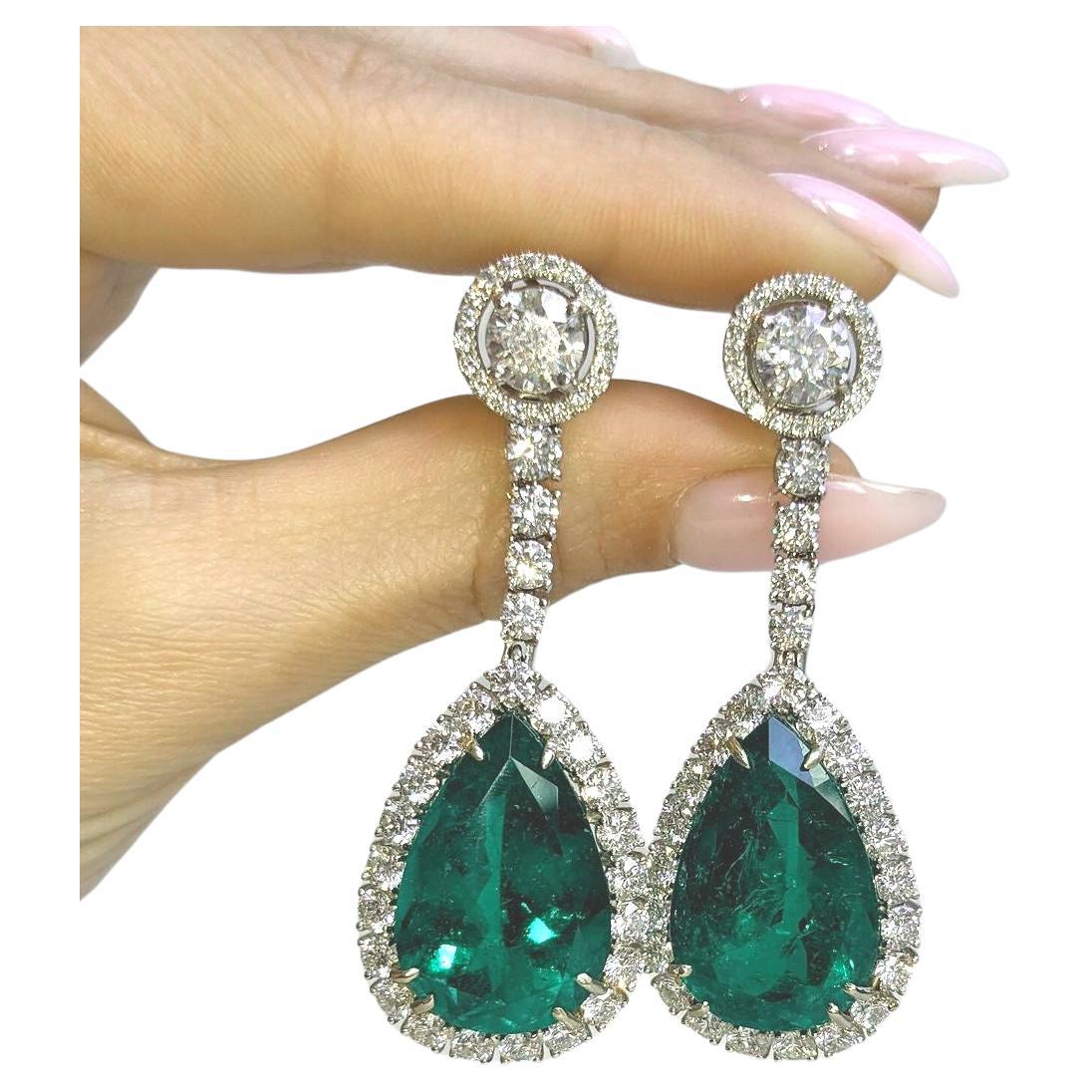 These elegant drop earrings feature two stunning pear-shaped Colombian emeralds, certified by C.Dunaigre for minor oil treatment. 

The emeralds, with a total combined weight of 28 carats (one weighing 15.24 carats and the other 13.20 carats),