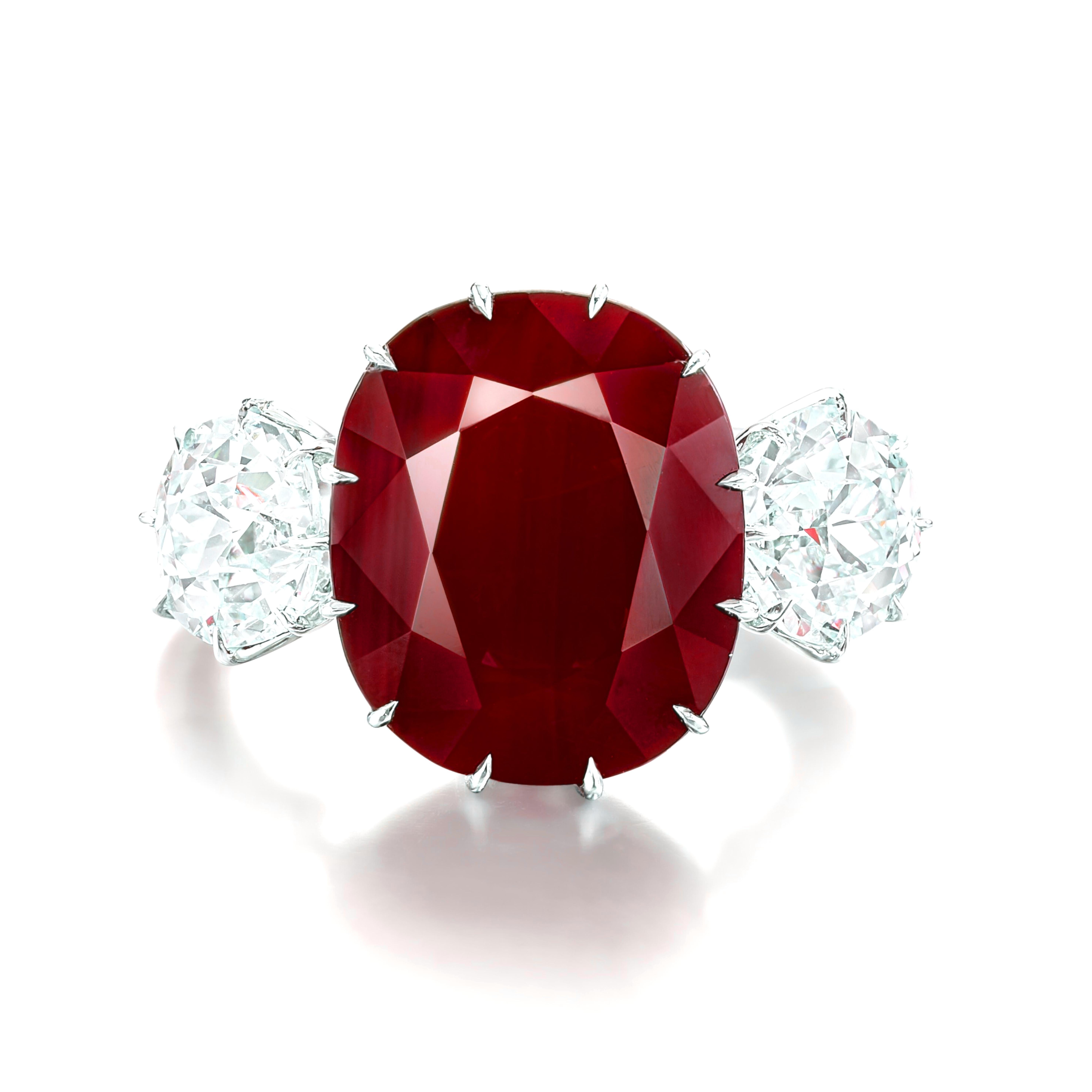 A magnificent statement of refined luxury, this exceptional three-stone ring features a 7.57 carat vivid red ruby, certified by C. Dunaigre as natural origin. Masterfully cut in a classic step-cut octagonal shape, the ruby displays rich saturation