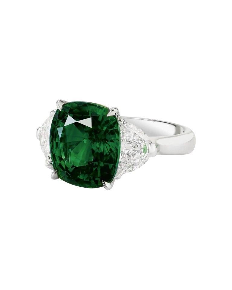 Questo splendido anello presenta uno smeraldo naturale certificato del peso di 3 carati, completato da eleganti diamanti con taglio a trapezio su entrambi i lati. Il verde vibrante dello smeraldo è splendidamente evidenziato dall'elegante