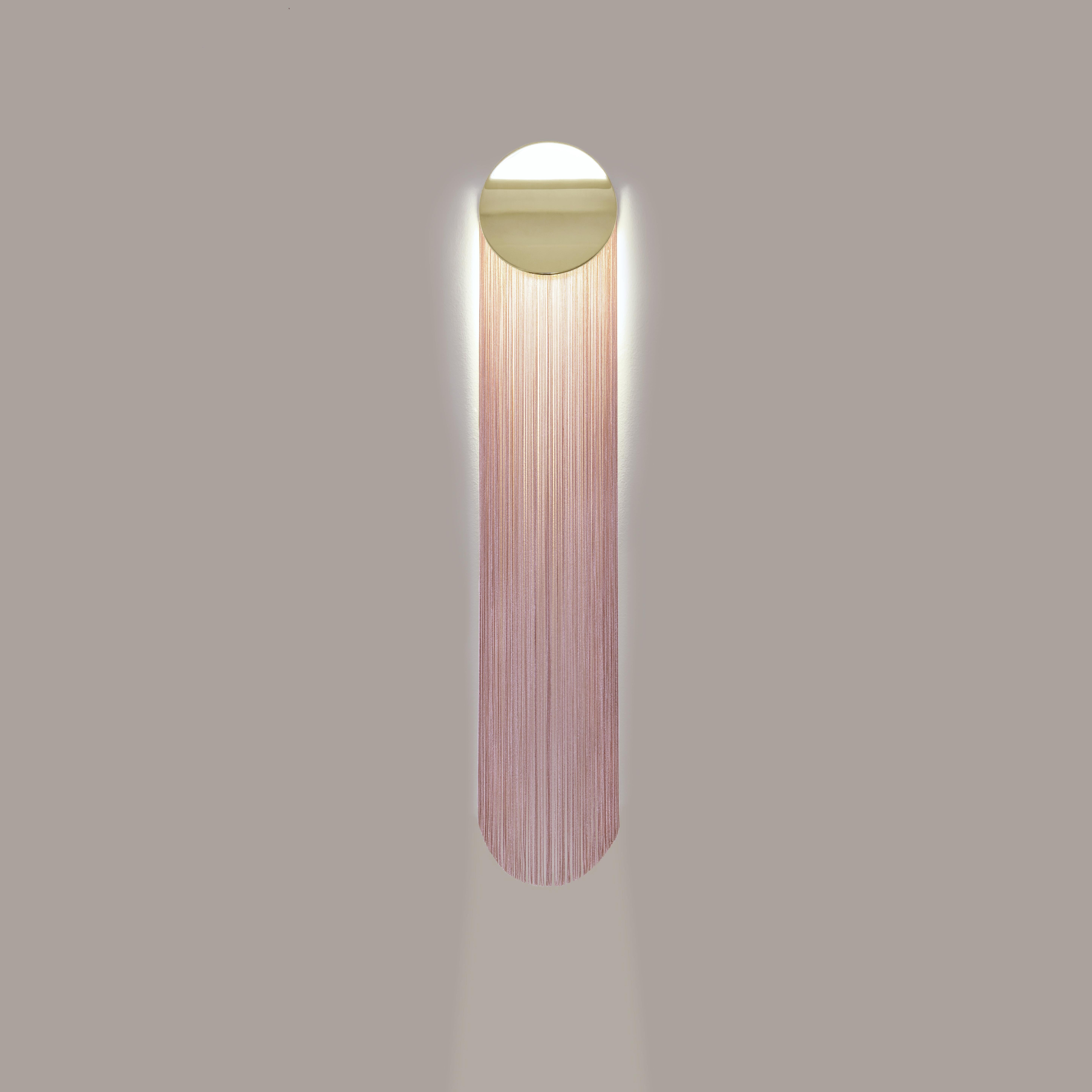 Cé Petite is a contemporary wall sconce with fringes and soft curves.

Cé jostles the obvious association between fringes and lighting by unveiling a classic revisited. The inspiration came from Cécrops, who would be the first native, the founder