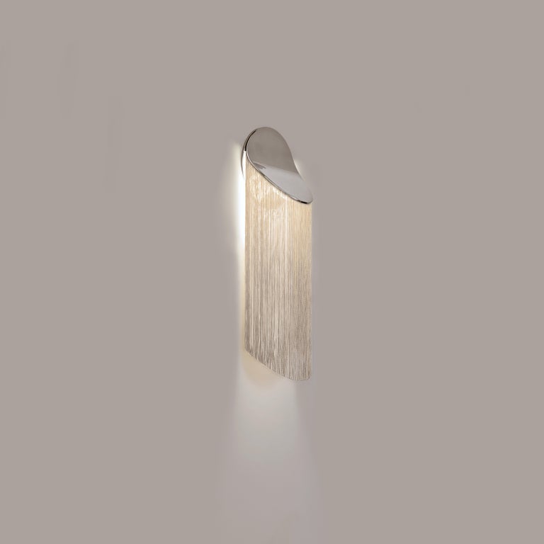 Cé Petite is a contemporary wall sconce with fringes and soft curves.

Cé jostles the obvious association between fringes and lighting by unveiling a classic revisited. The inspiration came from Cécrops, who would be the first native, the founder