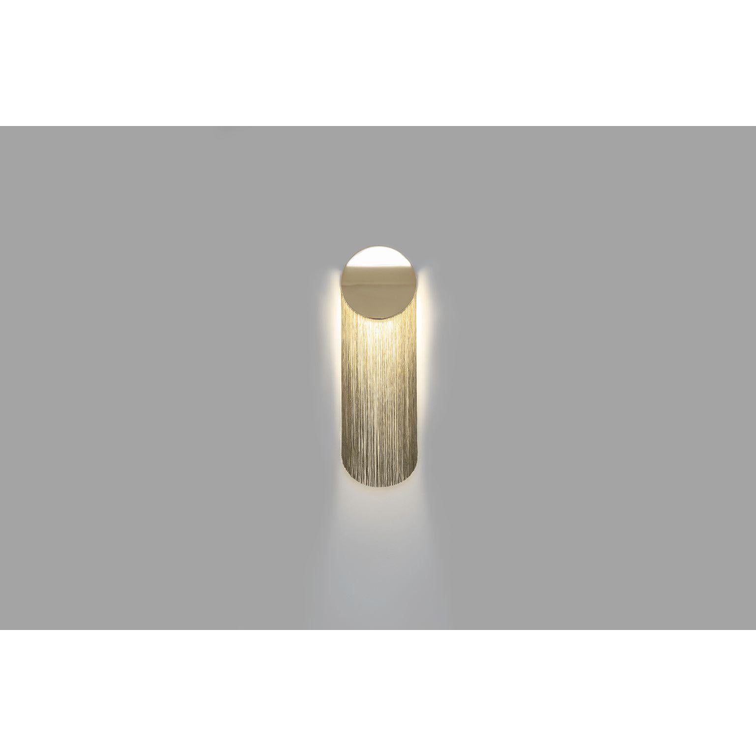 Cé Petite wall lamp short by Studio d'Armes
Design by Alexandre Joncas
Dimensions: 9.9 x 16.5 x H 50.8 cm
Materials: 12k Gold Plated Steel, Rayon fringes offered in different colors
Design by Alexandre Joncas
Cé Petite, with abridged proportions,