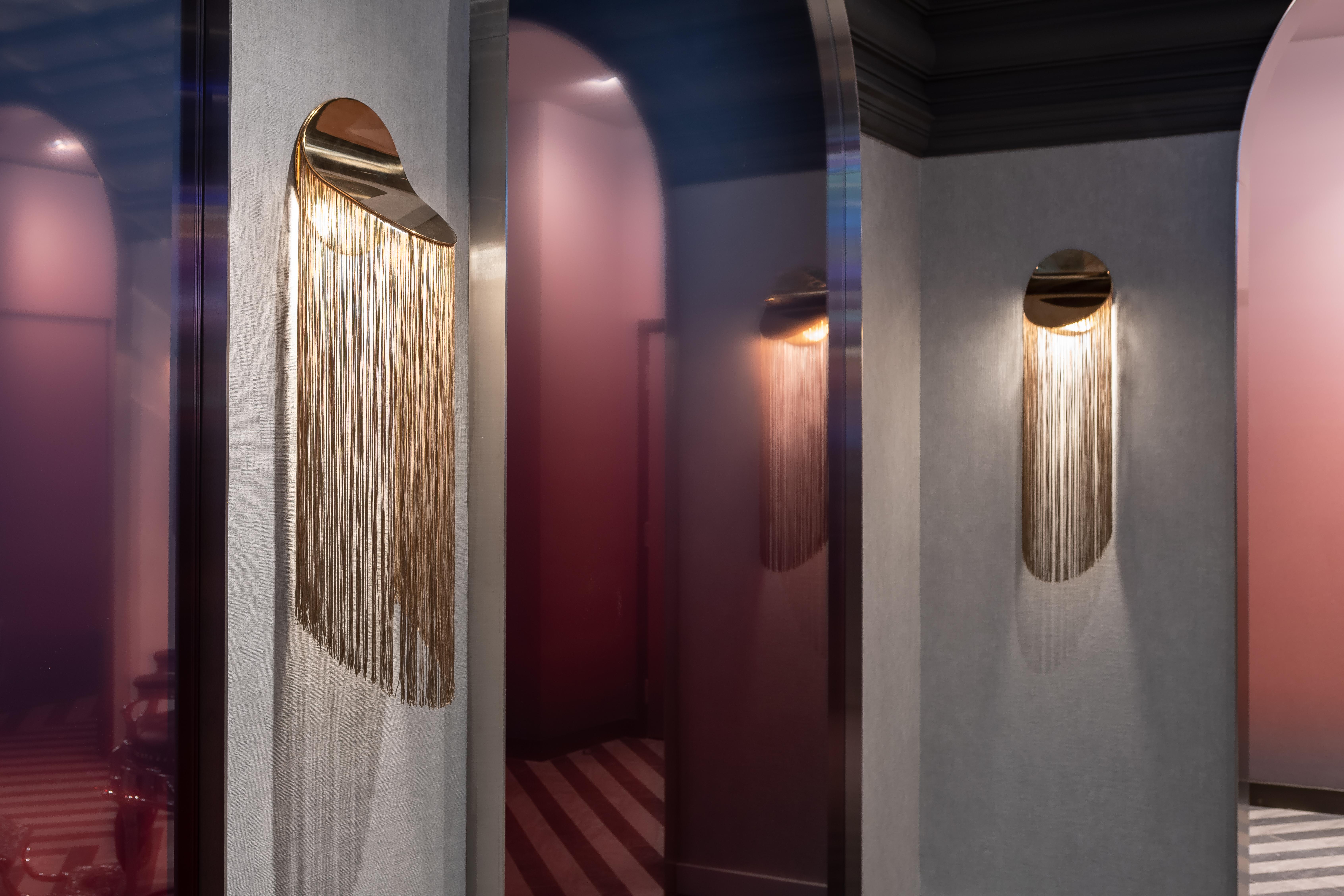 Cé Wall is a contemporary wall sconce with fringes and soft curves. The unique movement of the fringes brings a fluid effect, distinguishing this piece from previous collections, all the while remaining faithful to the minimalist look of candid