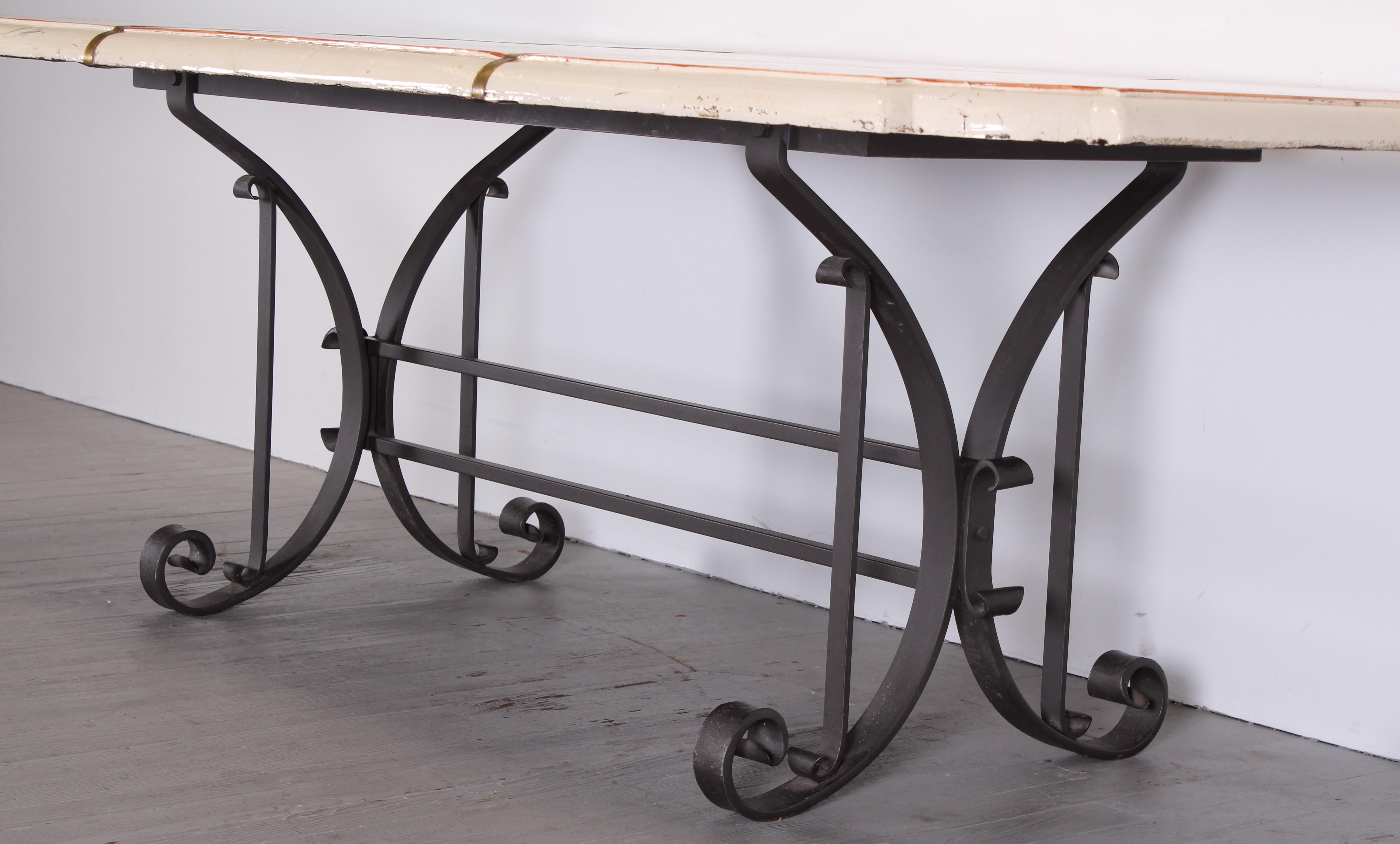 A wonderful hand painted ceramic Italian table with inset brass straps on a wrought iron base. Signed on the edge of the table by Ceccarelli. Some wear to ceramic as shown in images that fits the character of the table giving it an antiqued look. We