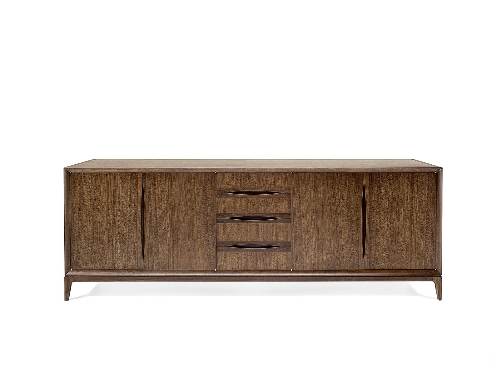 Designed by CC Studio in 2012 for Ceccotti. This elegant credenza is in a Dark American Walnut. Its almost monolithic architecture is lightened by its slender legs. Brad offers plenty of storage space: as well as the four doors fitted with inside