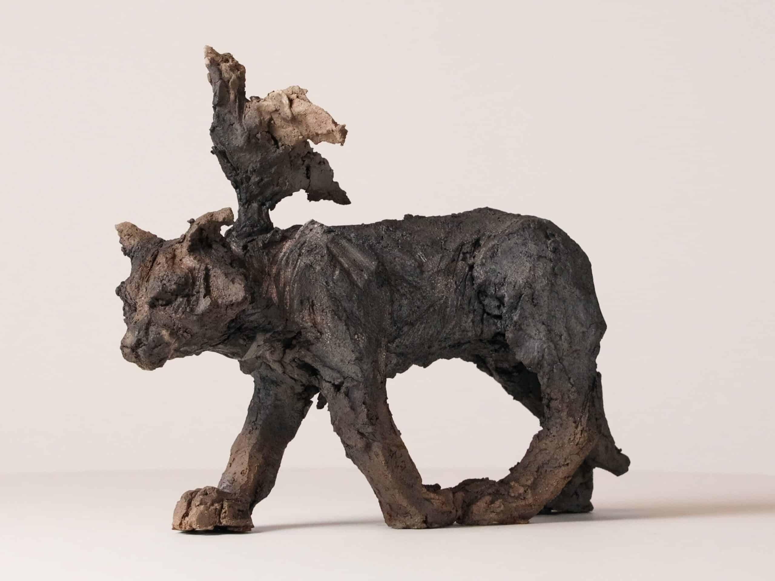 Cat/bird is a unique smoke-fired sandstone sculpture by French contemporary artist Cécile Raynal, dimensions are 30 cm × 11 cm × 24 cm (11.8 × 4.3 × 9.4 in). 

This artwork ironically depicts a cat with a bird on his back. This piece is a part of
