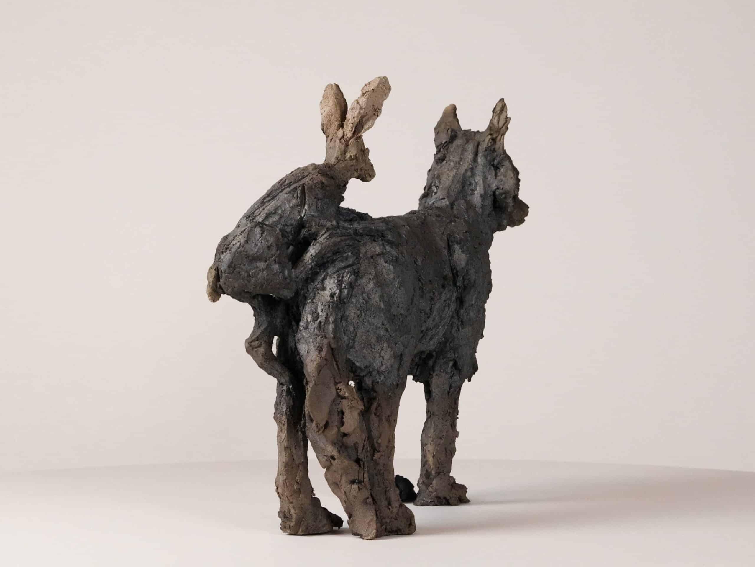 Hare and wolf is a unique smoke-fired sandstone sculpture by French contemporary artist Cécile Raynal, dimensions are 33 × 42 × 16 cm (13 × 16.5 × 6.3 in). 

The sculpture depicts an ironic scene: a hare is being attacked by a wolf, but the wolf is
