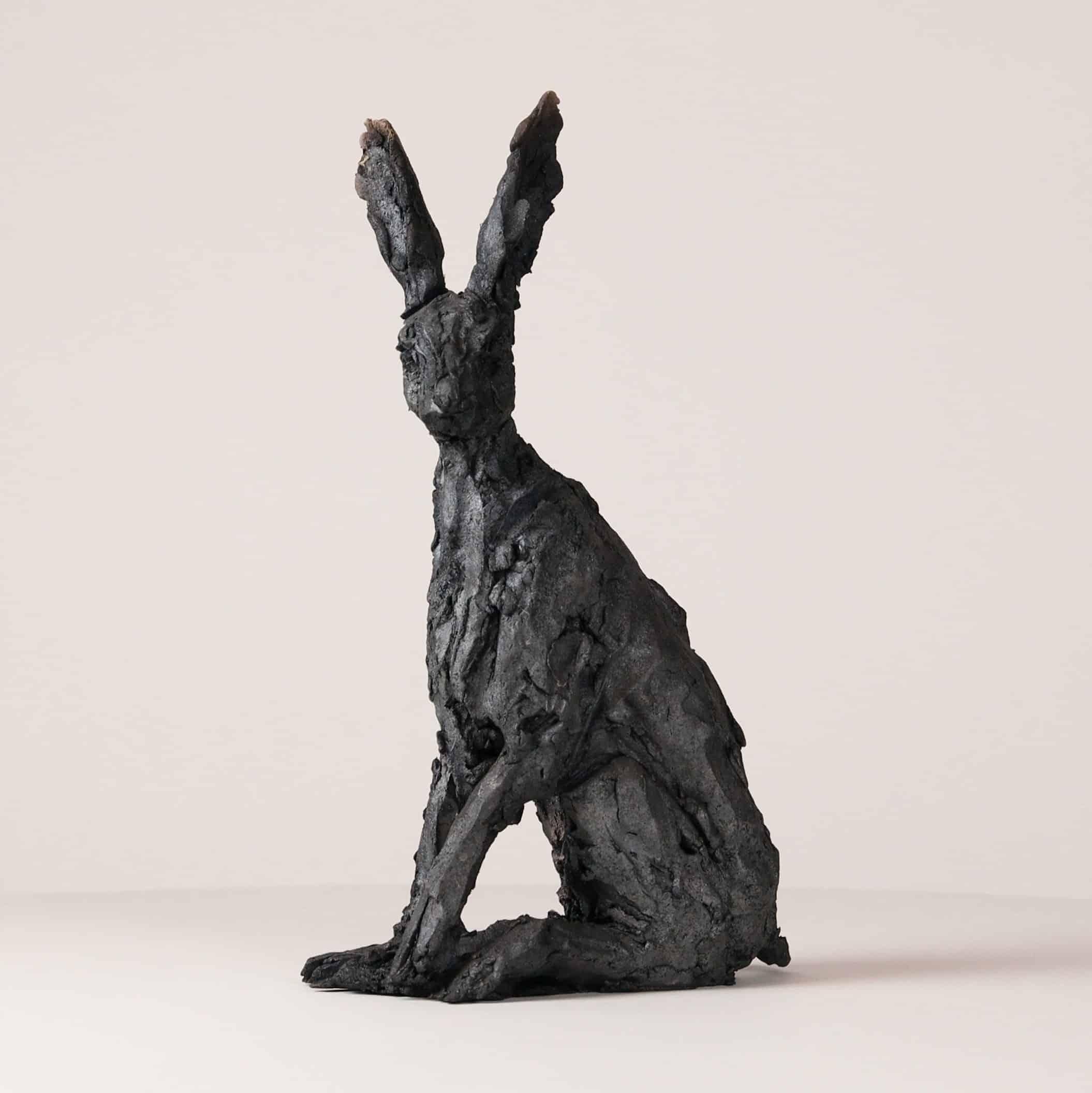 Seated hare is a unique smoke-fired sandstone sculpture by French contemporary artist Cécile Raynal, dimensions are 32.5 × 20 × 10 cm (12.8 × 7.9 × 3.9 in). 

This artwork depicts a watchful and active hare. However, the observer can see right away
